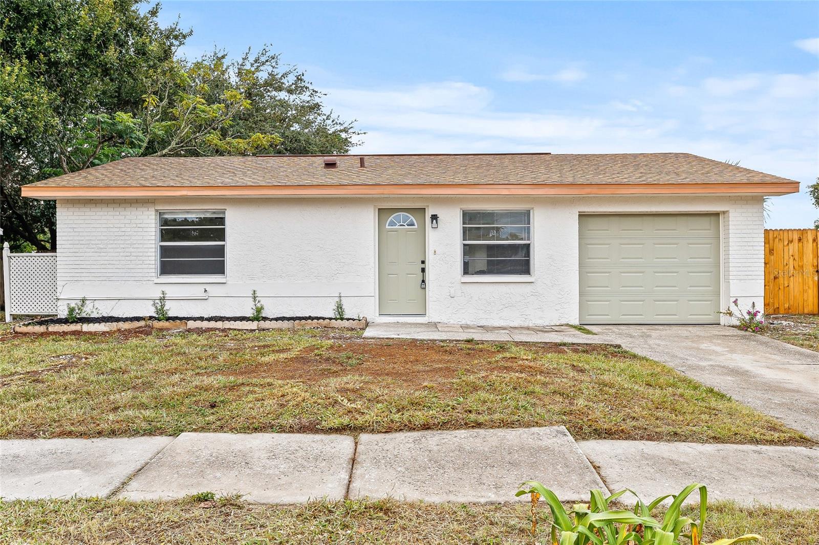 Welcome to this charming, newly renovated 3-bedroom, 2-bathroom home nestled in a quiet Port Richey neighborhood outside of a flood zone. From the moment you arrive, you'll love the cute curb appeal and inviting walkway that leads into a light-filled, open-concept interior. Inside, you’re greeted by a bright and airy floor plan where the living and dining areas flow seamlessly into a stunning kitchen—complete with brand-new cabinets, sleek stone countertops, and stainless steel appliances. The split floor plan offers ideal privacy, with the spacious primary suite located on one side of the home, featuring a luxurious ensuite bathroom. On the opposite side, you’ll find two generously sized guest bedrooms and a trendy, fully updated guest bathroom. The home also includes a practical indoor laundry room, designed for comfort and convenience. Step outside to a large, fenced backyard, perfect for entertaining, relaxing, or letting pets play freely. Additional peace of mind comes with a brand-new roof (2025), ensuring years of worry-free living. This home is ideally located just 15 minutes from Hudson Beach, 10 minutes from Gulf View Square Mall, and close to a variety of great restaurants and local conveniences. Don’t miss the opportunity to own this move-in-ready gem—modern updates, a functional layout, and a great location all in one!