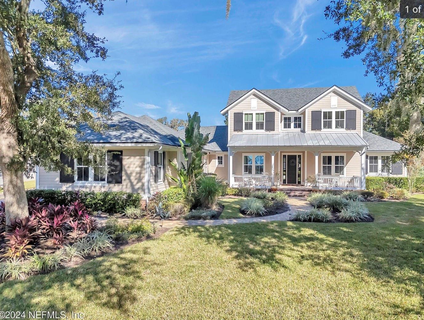 Discover the pinnacle of luxury in this breathtaking executive estate, perfectly perched on a 1-acre elevated lot within a desirable gated community along the scenic St. Johns River. Tucked away in an idyllic enclave adorned with majestic Live Oak trees just off Mandarin Road, this custom Glenn Layton masterpiece is a rare find that won't last long. Step onto the charming front porch to savor river sunsets or retreat to the serene backyard, where a brand-new (completed July 2024) detached guest house awaits. This private oasis is surrounded by lush Sylvester Palms, fruit trees, and tranquil water fountains. The guest house, a marvel of modern design, features two bedrooms, a full bath, a laundry room, a living area, and kitchenette—ideal for visitors and added privacy. The main home is a showcase of craftsmanship and thoughtful design, with custom trim work and finishes throughout. From the moment you enter the two-story foyer, you'll notice the reclaimed brick accents, a push-button fireplace, and a sliding glass wall that opens to reveal panoramic views of the expansive backyard. The seamless indoor-outdoor connection creates the perfect backdrop for relaxing or entertaining. The kitchen is a chef's dream, featuring a sprawling island, Thermador appliances, a custom tile backsplash, and a hidden walk-in pantry. This open-concept space is as functional as it is beautiful, designed for both everyday living and special gatherings. Warm wood floors flow throughout the home, adding timeless elegance and charm. With 5 spacious bedrooms and a versatile front room currently used as a home office, this home offers the flexibility to accommodate your every need. The oversized three-car garage boasts epoxy floors, a charging station, and ample space for storage. A whole-house generator ensures peace of mind, while neighborly privacy hedges provide a secluded retreat for your outdoor living spaces. Control every aspect of this state-of-the-art "smart home" with ease using the integrated Control4 system or your favorite smartphone app. For families, a pool safety fence (not pictured) offers added peace of mind. Just steps from the river and close to top-rated schools and shopping, this home is the ultimate blend of luxury, comfort, and convenience. Plus, take advantage of an assumable ARM at an incredible 2.375 interest rate until May 2026. Don't miss your chance to own this one-of-a-kind property.