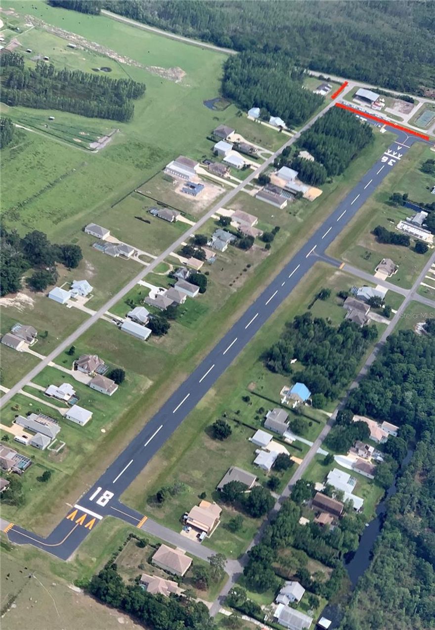 Pilot Country Airport, just 13 miles south of Brooksville, FL, is not just a location; Pilot Country Airport represents a rare opportunity to acquire a fully operational, privately owned, public-use airfield and established residential airpark in Pasco County, Florida—strategically positioned along the rapidly expanding State Road 52 corridor within the high-growth Tampa Bay region.  This asset combines proven aviation infrastructure, consistent in-place income, and significant development upside, creating a compelling opportunity for both aviation operators and real estate investors. With increasing regulatory barriers, zoning constraints, and land scarcity, new airport development in this region is extremely limited, making existing, licensed airfields highly defensible and effectively irreplaceable assets. The airport features a paved runway (18/36) measuring approximately 3,700 feet long by 75 feet wide, suitable for a wide range of general aviation aircraft. The runway was resurfaced in 2020, and the full lighting system was upgraded the same year, providing reliable pilot-controlled lighting for safe nighttime operations. Recent capital improvements further enhance operational capacity and revenue potential. A newly constructed (2024) 100’ x 100’ box hangar with a large fold-up door provides modern, high-demand storage for larger aircraft. A recently refurbished shade hangar accommodates up to 14 aircraft, complemented by approximately 10 outdoor surface tie-down positions. Notably, both hangar space and tie-down positions are consistently 100% occupied, underscoring strong demand and providing immediate, stable income with clear mark-to-market upside.  The airport is equipped with 24/7 self-service 100LL fuel, supporting both based tenants and transient traffic. This existing infrastructure provides a strong foundation to scale fuel sales and expand aviation services, including maintenance, avionics, and flight operations—unlocking additional high-margin revenue streams. From an operational standpoint, the airport benefits from a favorable airspace position—located outside of congested controlled airspace while maintaining convenient access to the Tampa Bay metro area. This allows for efficient, less restricted operations, a key advantage for both recreational and business aviation users.
The property also offers significant real estate and development potential. Approximately 10.34 acres of frontage along State Road 52 are zoned C-2 commercial, allowing for a wide range of uses including aviation-related services, flex industrial, retail, or mixed-use development. The frontage can be configured in multiple ways, providing flexibility for a full-site acquisition or partial sale strategy. The location is a major driver of long-term value. State Road 52 is currently undergoing significant widening and infrastructure improvements, transforming it into a primary east-west corridor across Pasco County. The property is located less than 10 minutes from the new Moffitt Cancer Center Pasco County campus, a major regional healthcare and employment hub expected to catalyze substantial residential and commercial growth. Value-add and expansion opportunities include: Development of additional hangars (T-hangars, executive hangars, or hangar condominiums); Expansion of tie-down and aircraft storage capacity; Scaling fuel operations and introducing additional aviation services; Commercial development along SR-52 frontage and more!
