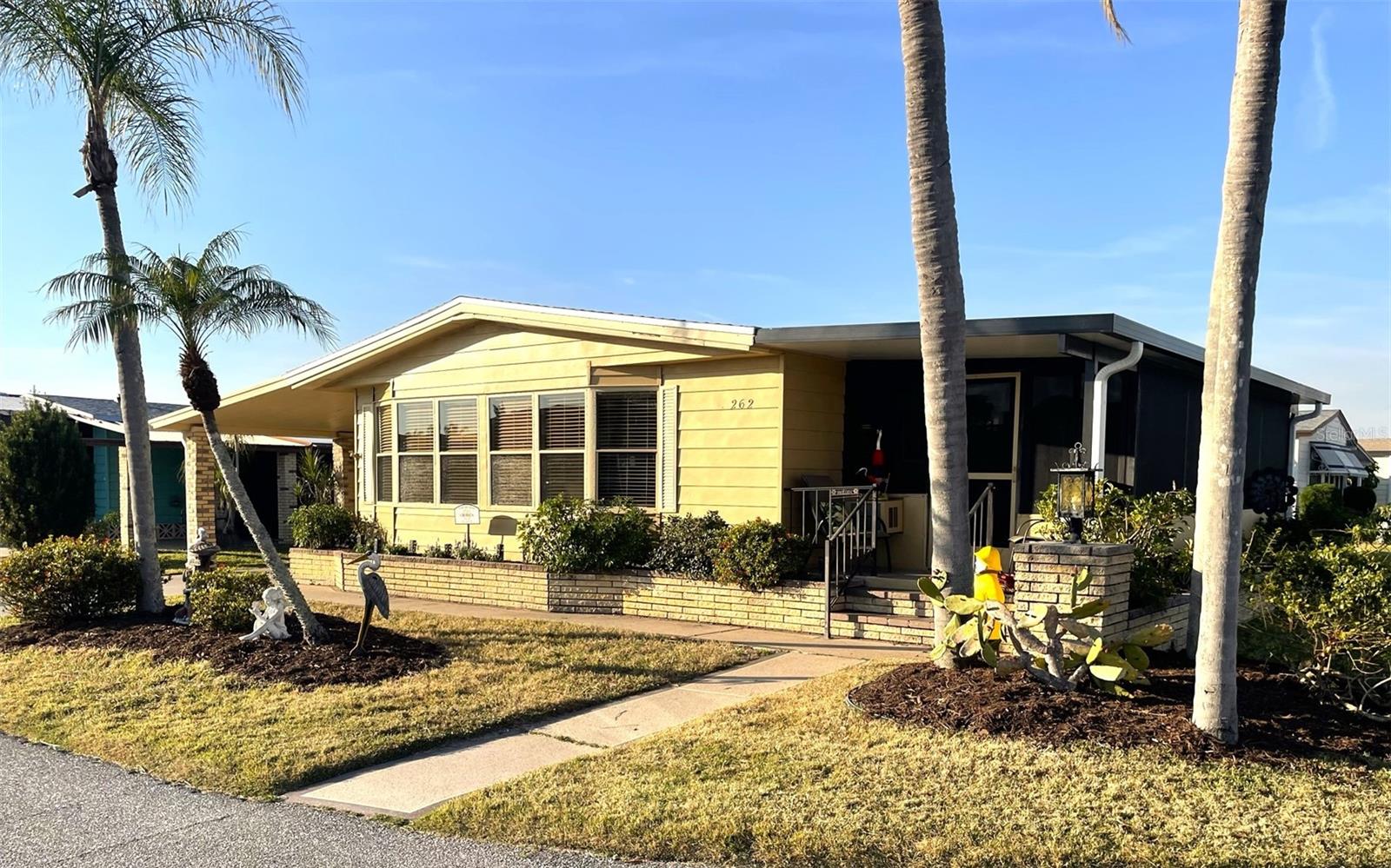 Nestled on a desirable corner lot in the sought-after, resort-style community of Harbor Isles, this unique and spacious 2-bedroom, 2-bathroom manufactured home offers an abundance of living and entertaining space. The thoughtfully designed layout features a bright and inviting family room with an amazing built-in bar—perfect for entertaining guests—as well as a spacious living room that seamlessly connects to an extra-long Florida room with acrylic windows, allowing for year-round enjoyment. The newly remodeled kitchen is a standout, boasting solid wood cabinets, stunning countertops, and brand-new stainless-steel appliances. Tile floors installed over ¾-inch plywood subfloors ensure both durability and style throughout the home. Vaulted ceilings and skylights enhance the open, airy feel while bringing in an abundance of natural light. The primary suite is a private retreat, offering two closets—including a large walk-in—and a spacious ensuite bath. A second bedroom and full bath provide ample space for family or guests. Step outside to the expansive screened-in lanai, ideal for enjoying Florida’s gorgeous winter days. Just off the lanai, a large storage shed houses the laundry area, complete with a built-in utility sink. Additional upgrades include a brand-new roof, a brand-new AC system, and fresh exterior paint (2022), making this home truly move-in ready. Harbor Isles is an exceptional, waterfront, 55+ gated community offering resort-style amenities and an active lifestyle. Residents enjoy a heated pool and spa, fitness center, tennis and pickleball courts, shuffleboard, bocce ball, and a spacious clubhouse with a vibrant social calendar. The community also features a private marina with boat slips, a kayak launch, and fishing areas, perfect for enjoying Florida’s coastal lifestyle. Beautifully maintained walking and biking paths wind through the lushly landscaped grounds, providing a picturesque setting for morning strolls or evening relaxation. Conveniently located near shopping, dining, world-class beaches, and cultural attractions, Harbor Isles offers the best of Florida living in a welcoming, friendly environment.