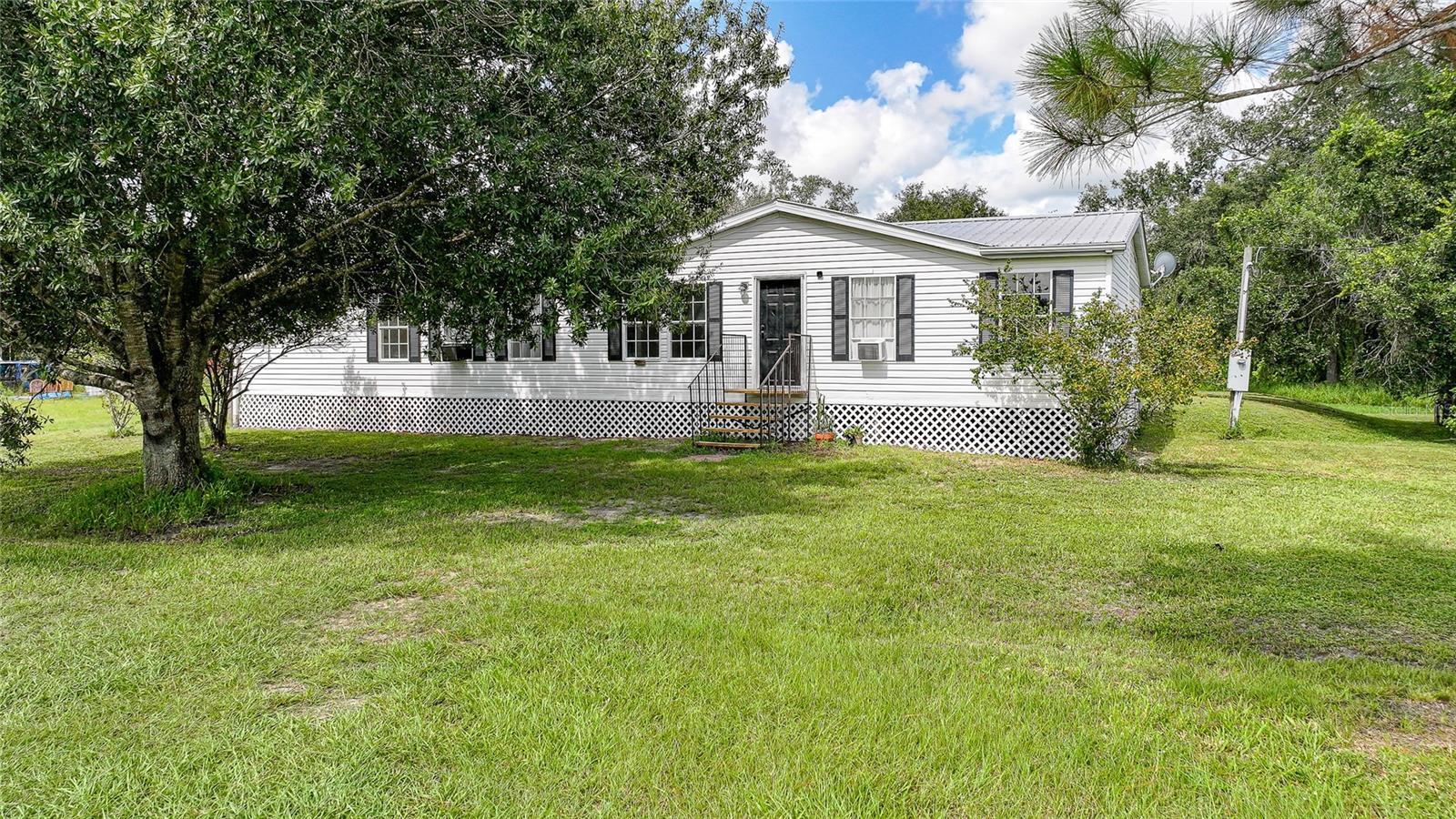 Ready to trade the noise of the city for some peace, quiet, and wide-open skies? This three-bedroom, two-bathroom country charmer is calling your name. Step inside and you’ll notice the fresh updates right away! New flooring in the living room, crisp paint, and a kitchen that’s basically begging you to host dinner. It’s big, it’s bright, it’s got an island/breakfast bar for pancake mornings, a closet pantry for all the snacks, and plenty of space to cook, chat, and hang out. There’s even a large laundry/mudroom, so muddy boots, wet paws, and sports gear all have a place to land (instead of piling up in the living room). The primary suite? Let’s just say it’s more than a bedroom. It’s a retreat. You get a walk-in closet that could handle even the most serious shopping habit, plus a spa-like bath with double sinks and a soaking tub made for your favorite beverage, bubbles, and zero interruptions. Outside, the new skirting gives the home a polished look, and the metal roof? It's only a couple years old which means one less thing to worry about. And the best part? The country setting. It’s peaceful, it’s private, and it’s the kind of place where evenings feel a little quieter, mornings taste better with coffee, and life slows down in all the right ways.