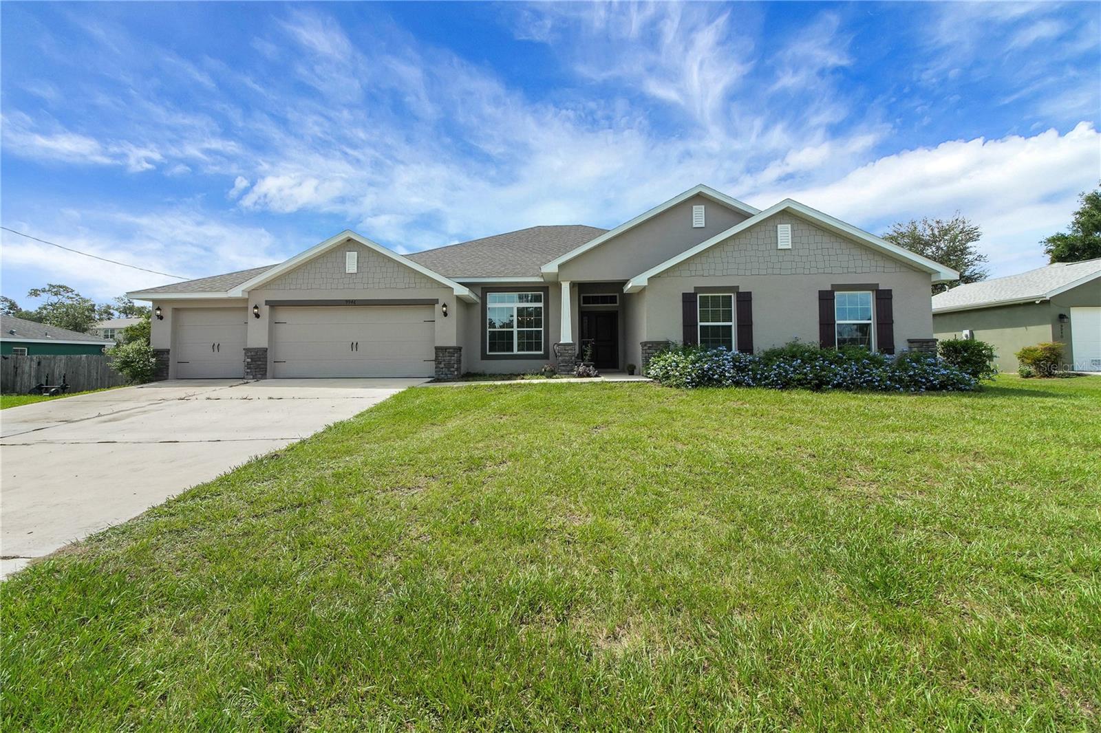 Welcome home to this spacious 4-bedroom, 3-bathroom, 3-car garage, block/stucco residence offering over 2,900 square feet of living space. This home was built in 2022 on a 0.29 acre lot. Inside, you’ll be greeted by tall ceilings, a versatile open floor plan, and two inviting living areas. The eat-in kitchen is perfect for gathering, featuring stainless steel appliances, a center island, a peninsula with breakfast bar seating, abundant cabinetry, and a walk-in pantry for all your storage needs. A generous laundry room adds even more storage and includes direct access to the backyard. The primary suite is a true retreat, complete with a tray ceiling, crown molding, and a spa-like bathroom boasting dual walk-in closets, double vanities, a private water closet, walk-in shower, and soaking tub. Three additional bedrooms provide ample space, including one with its own walk-in closet. Step outside to the covered back porch—ideal for relaxing in the shade while enjoying the outdoors. With a new roof installed in 2022, this home offers both comfort and peace of mind. Conveniently located in Summerfield near shopping, dining, and more!