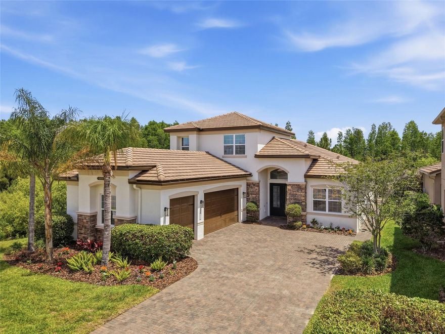 Welcome to 30567 Chesapeake Bay Dr. The Julia Grande Floorplan by GL Homes, located in the highly desirable community of The Ridge at Wiregrass Ranch. This impeccable residence showcases an impressive collection of custom features both inside and out, offering true turnkey living. This sought-after split-bedroom floor plan offers nearly 3,000 square feet of living space on a beautiful conservation lot with picturesque views, featuring 4 Bedrooms, an Upstairs Bonus Room, 3.5 Baths, a 3-Car Garage, a Heated Screened-In Salt-Water Pool, and a Fully Fenced Yard.

Upon arrival, you’ll immediately notice the home’s impressive curb appeal and expansive driveway. Step through the elegant double glass doors into a grand foyer with soaring coffered ceilings that seamlessly opens into a welcoming Great Room highlighted by beautiful tile flooring and a stunning electric fireplace feature wall. Large sliding glass doors draw your attention straight to the spacious backyard oasis, where the screened-in salt-water pool, outdoor kitchen, serene conservation setting, and picturesque views create the perfect backdrop for both relaxing and entertaining.

Back inside, the chef’s dream kitchen features upgraded cabinetry, quartz countertops, high-end appliances, a gas stove, stainless steel hood, oversized peninsula, casual dining area, and an open flow designed perfectly for everyday living and hosting alike.

The elegant primary suite is tucked at the rear of the home and features large windows, a coffered ceiling, dual custom closets, and a spacious primary bath with double vanities and a large walk-in shower. One wing of the home offers two secondary bedrooms and a full bath, while the opposite wing includes an additional bedroom with its own nearby full bath. The upgraded laundry room includes upgraded custom cabinetry and a sink for added convenience.

Upstairs, you’ll find a versatile loft/flex space with a half bath, ideal for a guest suite, home gym, office, media room, or playroom.

Noteworthy upgrades totaling nearly $200K include a newer pool, outdoor kitchen with hibachi grill, new AC units, new exterior paint, fresh interior touch-ups, water softener with reverse osmosis system, electric fireplace, waterproof laminate flooring, custom closets, custom woodwork throughout, tesla charger in garage plus 4 upper hanging storage racks, upgraded kitchen cabinetry, newer appliances, fully fenced yard, gutters, and so much more.

The home is complete with a tile roof, brick paver driveway, and automatic sprinkler system. The Ridge offers resort-style amenities including a beach-entry pool, waterslide, lap pool, tennis courts, sports courts, volleyball, playground, playfield, fitness center, game room, social hall, party pavilion, and more. HOA includes lawn mowing, limited landscape maintenance, fertilization, mulching, and exterior pest control.

Conveniently located near top-rated Wiregrass schools, I-75, The Shops at Wiregrass, The Grove, Wiregrass Sports Campus, Tampa Premium Outlets, hospitals, dining, and more, this home offers the perfect blend of comfort, upgrades, privacy, and convenience!