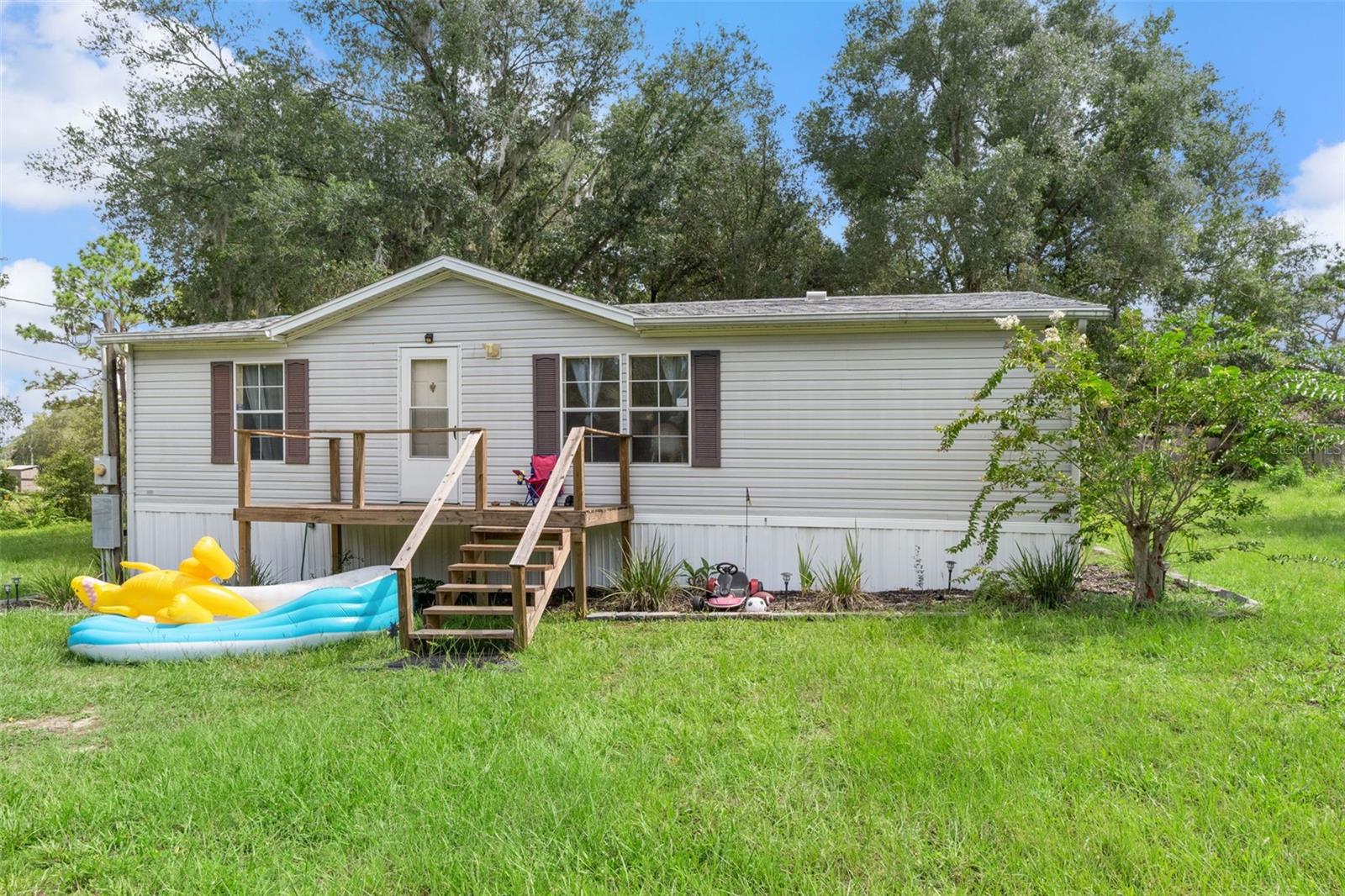 Discover this charming 2-bedroom, 2-bath mobile home nestled on 0.52 acres in the peaceful community of Lecanto, FL. Inside, an open living area flows seamlessly into the dining space and kitchen, creating a warm and inviting atmosphere. Outside, enjoy a spacious yard with a back deck that leads to an open-air patio and a tranquil koi pond—perfect for relaxing or entertaining. Conveniently located near local amenities, this property offers the ideal blend of comfort, charm, and convenience.