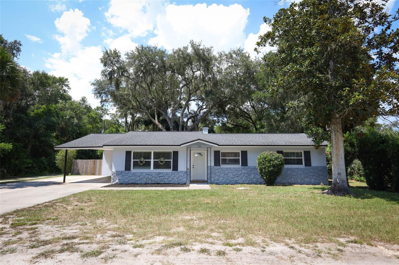 Discover the charm of small-town living in this beautifully maintained and tastefully updated 3-bedroom, 2-bathroom home offering 1,333 sq ft of comfortable living space. Nestled on a quiet dead-end street in the heart of Osteen this corner-lot gem comes with no HOA. Inside, you’ll find a cozy yet spacious living area with durable laminate plank flooring throughout the room & home. The open-concept layout flows seamlessly into the modern kitchen, featuring shaker cabinets, a new sink & stainless refrigerator, a cooktop bar with clear sightline to the living space—ideal for entertaining. A separate dining area offers easy access to the back patio and large backyard, perfect for relaxed BBQs and evening gatherings. The layout incudes a spacious primary suite with a totally renovated ensuite with pedestal sink and beautiful glass shower, two additional bedroom rooms and a fully renovated hall bath. You will love the oversized indoor laundry room with ample storage space located just off the dining room. Step outside to your private fenced backyard oasis—complete with a covered patio, wood deck, and outdoor firepit, all shaded by a picturesque historic oak tree. There’s also a storage shed for tools or hobbies and a play set for the little ones. Additional perks include a covered 1-car carport, extended driveway for extra vehicles, a boat, or small RV. Whether you're a first-time buyer, someone downsizing or an investor looking for a turnkey rental, this property checks all the boxes. Additionally, you will have peace of mind knowing all of the major home components have been updated too. Located in quaint Osteen with easy access to shopping, restaurants, schools, a post office, and the local community center. Commuters will appreciate proximity and easy access to 417, I-4, and Sanford Airport, while nature lovers will enjoy the nearby Osteen Bike Trail/trailhead and Lake Monroe & Palm Bluff Conservation Area. This home offers a short drive to downtown Sanford, Debary, Orlando, and the beaches. Don’t miss your chance—schedule your private showing today!.