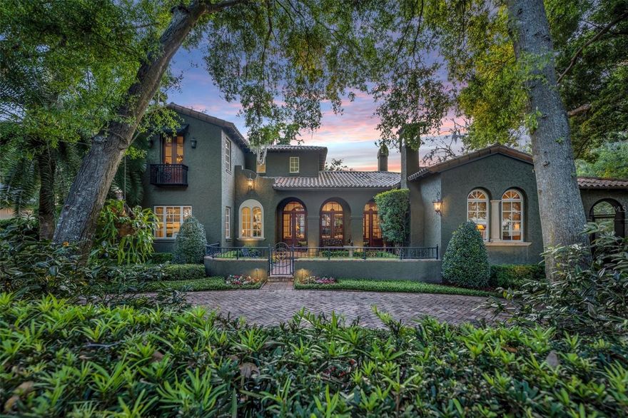 Presenting a rare opportunity nestled within the enclave of Twelve Oaks, one of the most coveted areas in Winter Park.  Set along a private drive with only a dozen residences this Spanish farmhouse was crafted under the discerning eyes of architect Gary Hancock and master builder Carlos Posada.  Spanning 5,320 square feet, this house boasts 5 bedrooms, 4 full baths and 2 half baths. It is the essence of “Olde Winter Park” but was built in 2002.  As you enter through the front courtyard and the custom front door you are welcomed into the gathering room adorned with a 13-foot pecky cypress beamed ceiling, Saltillo tile, and a stone fireplace.  There is a seamless transition to the loggia that opens to the serene courtyard.  The farmhouse gathering kitchen offers opportunities for cooking, dining, and conversation and also opens to the loggia.  The first-floor primary suite offers a vaulted ceiling, Australian cypress wood floors, large walk-in closet, adjoining room that can be for exercise or a sitting room to compliment the primary bedroom, and a “hidden” entrance into a fully wood paneled study with built in bookcases and fireplace.  The exercise room and study both open to another screened porch.  Upstairs you will find 3 bedrooms with 3 full baths and ample closets and storage.  The back courtyard is surrounded by beautiful flowers, landscaping and lighting and is covered with a canopy of trees.  You will find a fireplace, outdoor kitchen, dining area, and steps leading to the mother-in-law suite over the garage.  This well-loved home has been well maintained, with thoughtful details that add to its undeniable charm. Once described as “magical”, this property is truly the essence of Olde Winter Park living.  Close to the charming boutiques and restaurants on Park Avenue.