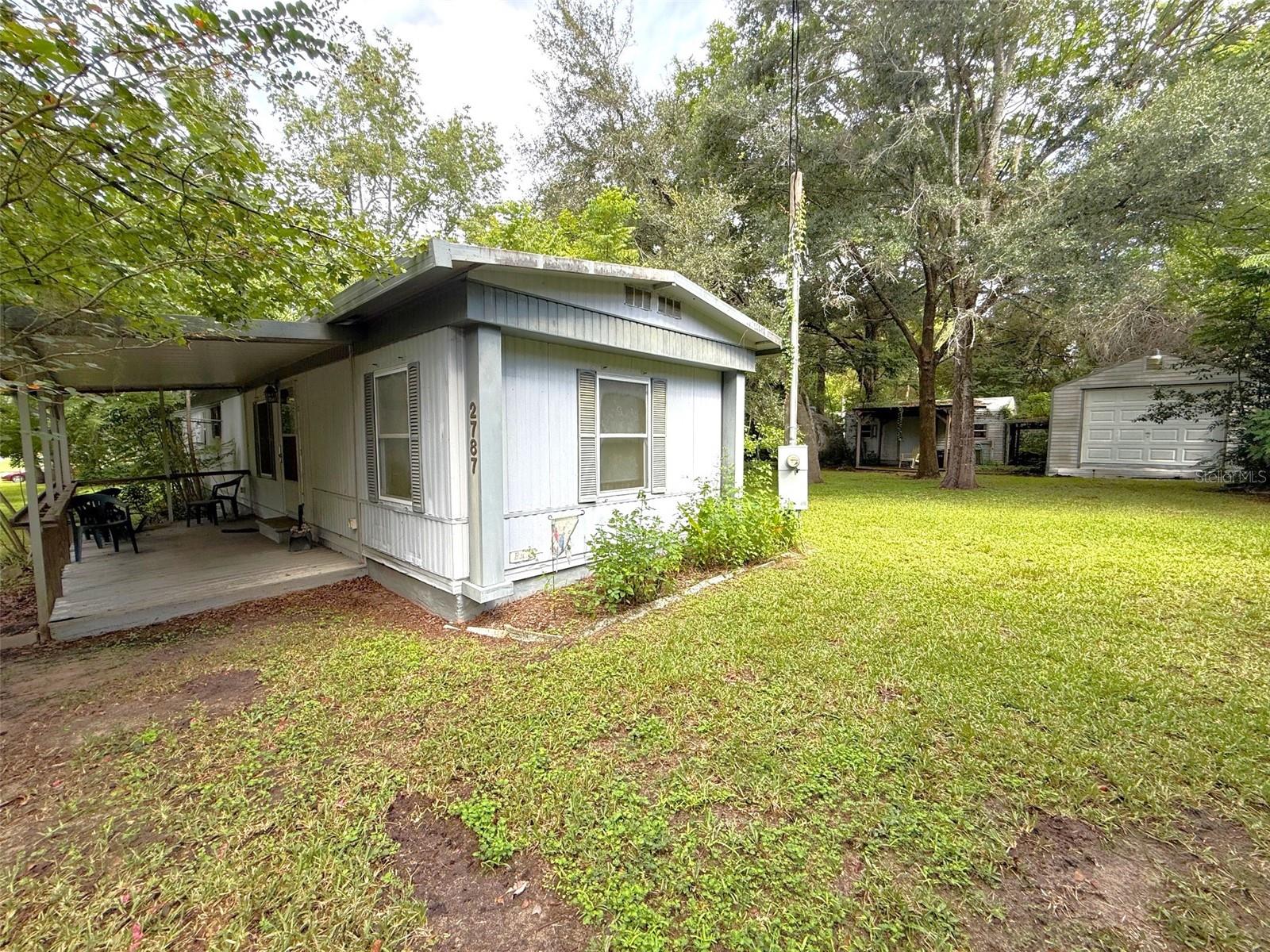 Home is move-in ready, 1980 model with 2 bedrooms, 2 baths plus office/den, inside laundry, living room with fireplace situated on mature landscaped fenced double lot. Exterior features include a large front and back screened porch, detached 1 car garage with roll-up door, shed and storm shelter. Ideally located near shopping, restaurants, banks and grocery stores. Don't miss out on this opportunity!