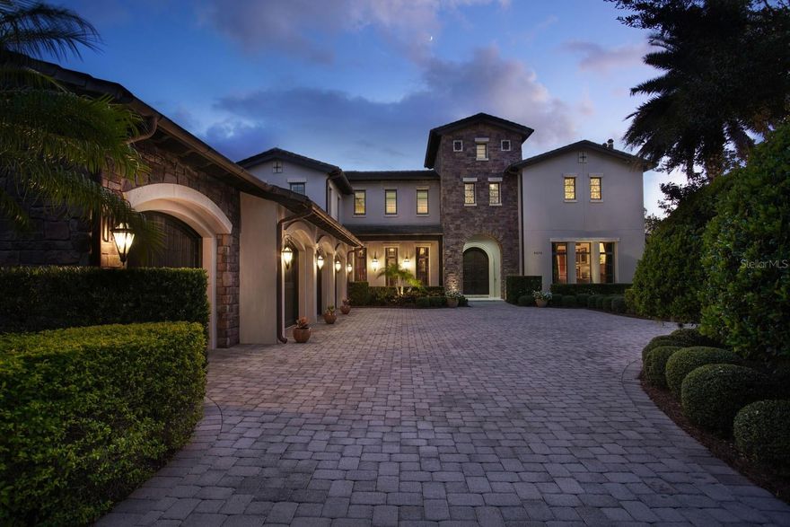 Surrounded by panoramic golf and water views, this two-story home sits on over half an acre of land and is truly a masterfully crafted estate. Distinguished by spectacular exterior and interior architectural elements, this transitional residence was built for both entertaining and comfortable living. Travertine floors with wood and tile inlay travel from the foyer throughout the main living areas and are further enhanced by custom wall treatments, columns and beautiful woodwork. The fully renovated kitchen is a chef’s delight with Thermador appliances, a Sub-Zero wine fridge, a center island and a hidden walk-in pantry, along with quartz countertops and white cabinetry. The family room features a built-in entertainment center and two sets of sliding glass doors that lead to the outdoor living area. The spacious floor plan also includes formal dining and living rooms, as well as a dedicated office. A sleek and modern staircase speaks to the contemporary feel of the home, acting as a focal point as it ascends to the second floor. Four of the five en suite bedrooms are located here, including the expansive owner’s suite with a morning kitchen, walk-through shower, freestanding tub and sauna. An impressive two-story closet with built-in dressers and granite countertops complete this updated retreat. The back exterior of the home, gracefully planned for optimum views and privacy, comes outfitted with a covered lanai with retractable screens, a summer kitchen, a sun deck and a pool with a lap lane and spa.