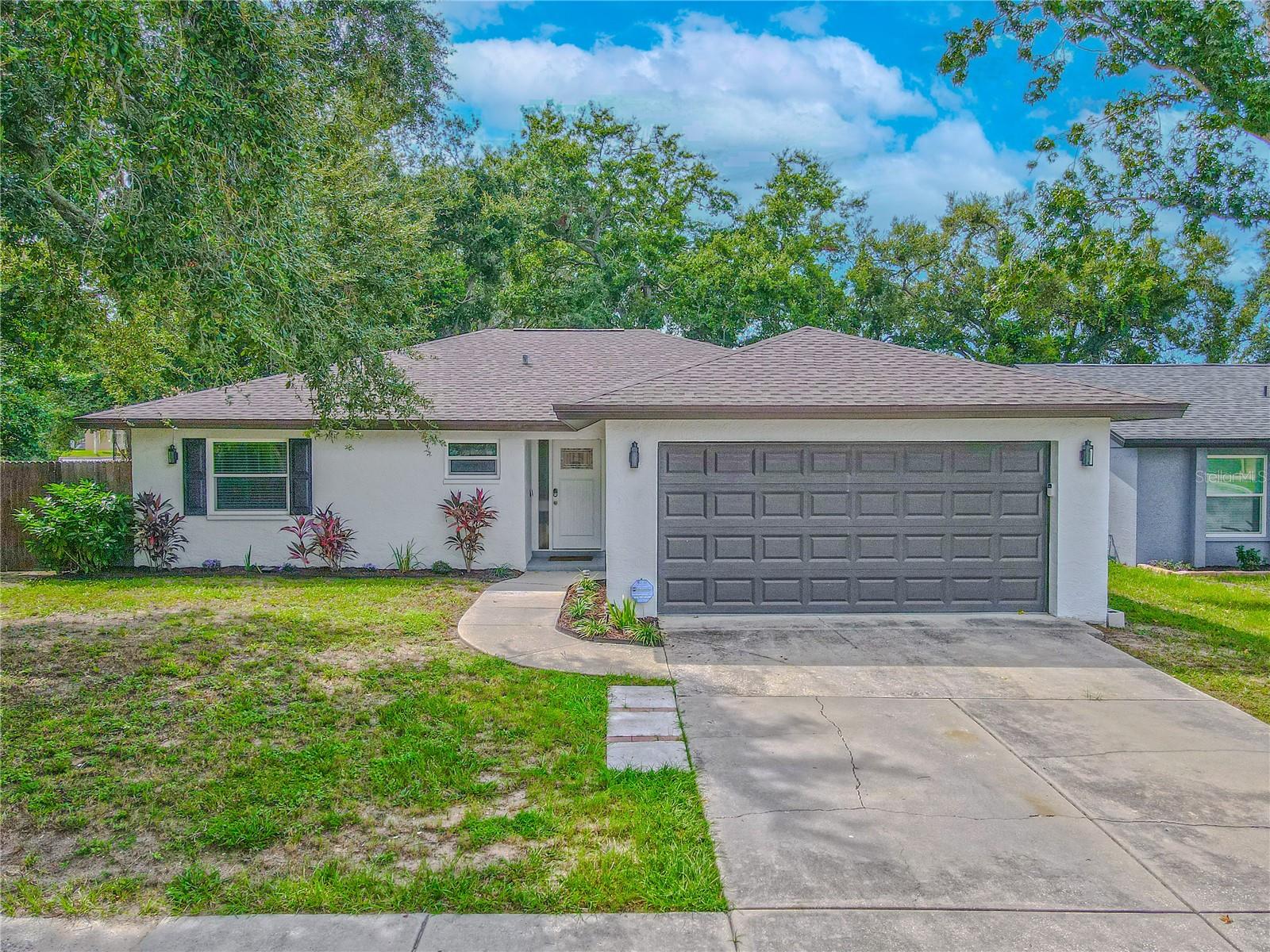 Welcome to this beautifully updated 3-bedroom, 2-bath home in Palm Harbor, where modern style meets a bright, open design. From the moment you arrive, the fresh curb appeal and inviting entry create a warm first impression. Step inside and you’re welcomed by an open-concept living space where wide-plank flooring, recessed lighting, and a neutral color palette create a bright and inviting atmosphere.
From the living room, the heart of the home unfolds. The kitchen boasts sleek cabinetry, quartz countertops, and a timeless subway tile backsplash. A large island with seating anchors the space, making it ideal for casual meals or entertaining. The full Samsung stainless steel appliance package, including refrigerator, dishwasher, and microwave, blends functionality with style, while a closet pantry adds convenience. The kitchen flows seamlessly into the dining area, a perfect setting for family dinners or gatherings with friends, before continuing back into the living room where the open layout ensures everyone stays connected.
The split-bedroom design offers comfort and privacy. The primary suite is positioned toward the back of the home, providing a spacious retreat with a ceiling fan and built-in closet. The en-suite bath is styled with dual vanities, modern fixtures, and a glass-enclosed shower finished in polished tile. At the front, two additional bedrooms feature ceiling fans with lights and built-in closets with shelving. They share a beautifully updated guest bath with a sleek vanity, subway tile surround, and charcoal gray tile flooring. A nearby linen closet adds convenience for everyday living.
From the living room, upgraded sliding glass doors open to a spacious enclosed porch that feels like an outdoor retreat. Fully screened and sheltered, it offers the perfect setting for morning coffee, casual dinners, or relaxing evenings while enjoying the view of the backyard. With room for both dining and lounging, this porch extends the home’s living space in a way that is comfortable year-round.
Beyond the porch, the fully fenced backyard provides both privacy and versatility. Whether hosting barbecues, creating a play area, or tending a garden, the possibilities are endless.
This home has been updated where it matters most, featuring a brand-new AC (2025) and a new roof (2023), offering peace of mind for years to come. An oversized two-car garage completes the home, with plenty of space for vehicles, tools, or outdoor gear, along with a dedicated laundry area that keeps everyday tasks tucked neatly away.
Not only is this home tucked at the end of a quiet street, it also offers a private walkway that connects directly to Reviere Shopping Center, where Publix, local restaurants, bars, and more are just a short stroll away. And when you’re ready for the outdoors, you’ll be minutes from John Chesnut Sr. Park, Lake Tarpon, Wall Springs Park, Sunset Beach, and Fred Howard Park. Golf enthusiasts will love the world-famous Copperhead Course at Innisbrook Resort, while quick access to US-19 keeps all of Tampa Bay within easy reach.