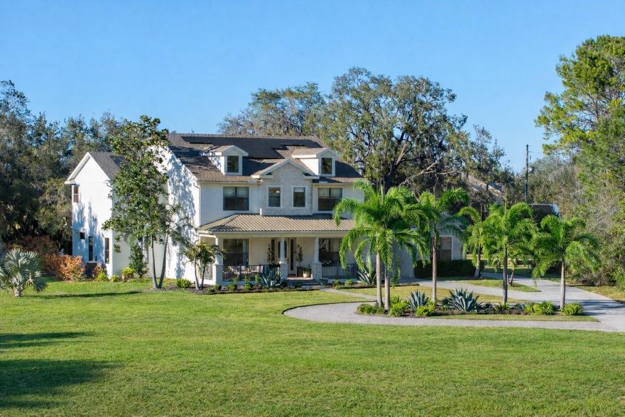 Privately gated and positioned at the end of a wooded cul-de-sac, this modern farmhouse estate spans nearly five acres with tranquil lake views and built-in hiking trails, offering a rare sense of privacy just minutes from Lake Nona.
You are welcomed by a sprawling front porch that immediately sets the tone for relaxed, refined living. Inside, a spacious entry showcases European white oak flooring throughout. The layout is intentional, with a great room on one side and a formal dining room on the other.
Renovated in 2024 with high end improvements, the home blends clean architecture with warm finishes. The kitchen features custom inlay cabinetry with LED underlighting, a leathered granite island, Venetian plaster hood, hidden walk in pantry, and a separate coffee nook with beverage refrigerator. The appliance package includes a 43 inch La Cornue induction range, 36 inch Monogram refrigerator and freezer columns, Fisher and Paykel double drawer dishwasher, ice maker, and multiple beverage centers.
The layout offers a first floor bedroom with a private en suite bath, while the remaining bedrooms are positioned upstairs for added privacy. The primary suite features a private balcony overlooking the lake and backyard. The spa inspired bath includes double vanities, steam shower, freestanding soaking tub, smart toilet, and a custom closet system.
A separate staircase leads to an expansive loft with an additional bonus bedroom, creating flexible space for a media room, office, gym, or guest suite.
Outdoor living includes a marble pool deck, custom pool and spa with water feature, summer kitchen, and dedicated pool bath. The property also includes a 1,000 gallon buried propane tank and paid off solar panels.
Additional highlights include a five car garage and an additional bay perfect for a workshop or gym. Having two laundry rooms, a custom mudroom, whole home water filtration, two tankless water heaters, two new AC units, a 2022 roof, and a whole house generator make the home even more impressive. Private acreage, lake views, and refined modern farmhouse design just minutes from Lake Nona create a rare opportunity for secluded luxury with everyday convenience.