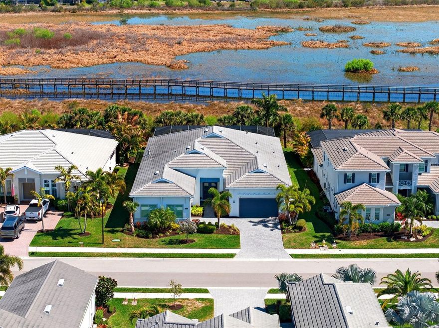Reimagined and impeccably refreshed, this home is an entertainer’s dream, offering generous spaces designed for effortless gatherings and elevated everyday living. Set on a premier preserve lot within the highly coveted Isles of Lakewood Ranch, this San Giorgio model embodies refined luxury and thoughtful design from the moment you arrive.  A grand entry with custom glass doors opens to a light-filled interior showcasing soaring 15-foot ceilings, expansive sightlines, and a seamless open-concept layout. Elegant finishes include impact-resistant windows and doors, and carefully curated lighting that enhances both form and function. The impressive great room features dramatic double tray ceilings and corner sliding glass doors that dissolve into the outdoors, framing tranquil nature views and extending the living space to the lanai.  At the heart of the home, the gourmet kitchen is as striking as it is functional, appointed with two-tone cabinetry, an oversized island with additional storage, quartzite countertops, a glass tile backsplash, under-cabinet lighting, a walk-in pantry, wine refrigeration, and top-of-the-line KitchenAid stainless steel appliances. The adjacent formal dining room flows effortlessly to the outdoor living area, creating a perfect setting for hosting on any scale.  Outside, the resort-inspired lanai invites year-round enjoyment with a saltwater lap pool featuring a gas heater and sun shelf, paver decking, a fully equipped outdoor kitchen, and a convenient cabana bath accessible from the lanai—all overlooking the serene preserve backdrop.  The owner’s retreat is a private sanctuary, complete with tray ceilings, a quiet sitting area, dual custom California-style walk-in closets, and a spa-like bath with dual vanities, an oversized soaking tub, and a separate walk-in shower. Additional accommodations include two well-appointed guest bedrooms, one with an en-suite bath and the other with the possibility of a Jack and Jill bathroom, a dedicated office or den, that could easily convert to a fourth bedroom, and a spacious laundry room with abundant cabinetry, granite countertops, and a folding area. Completing the home is a three-car garage with epoxy flooring, offering both practicality and polish.  This renewed and sophisticated residence delivers the ideal blend of elegance, comfort, and exceptional entertaining spaces in one of Lakewood Ranch’s most desirable communities.
Luxurious living in the gated, maintenance-free community of The Isles, nestled between The Lake Club and Concession, at its best! The Isles at Lakewood Ranch offers many amenities such as a 65,000 square foot clubhouse, tennis and pickleball courts, basketball court, playground, state of the art fitness center and yoga room, resort-style swimming pool and spa, boardwalk and fishing pier, and a playground and dog park. Centrally located, just off I-75 and a short drive to the award-winning beaches of Siesta Key, Lido, & Anna Maria. This move-in ready home has all the amenities that one would want in this 2025 Best-Selling Multigenerational Planned Community in the Nation.