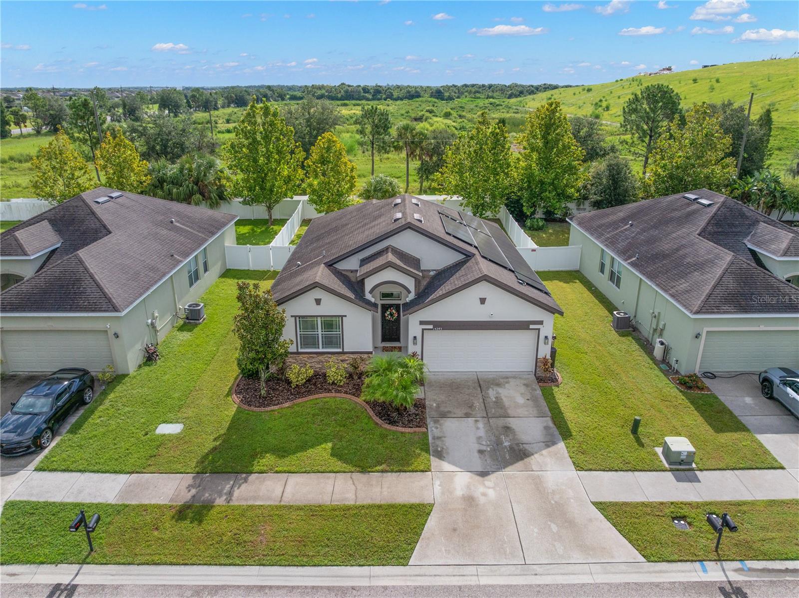 Welcome to Highland Estates where you will experience a vibrant community featuring amenities that include a fitness center, playground, walking trails, and a RESORT-STYLE pool with a clubhouse. This beautifully designed LGI built, Captiva split floor plan boasts three bedrooms, two bathrooms, and 1,633 square feet of living space. The exterior features a well-maintained lawn with concrete curbing, a stacked stone facade, and a covered entryway that provides shelter for guests and packages. Inside, the foyer offers a drop zone and separation from daily living. The GREAT ROOM is the heart of the home and includes the living space that has wood floors, a feature wall with a brick facade, and ample space for oversized furniture. The dining room has a CUSTOM accent wall with a geometric pattern that anchors the space! The kitchen includes two-tone painted cabinetry with crown molding, a window overlooking the backyard, and stainless-steel appliances from 2023, including a double CONVECTION oven. The primary bedroom is located at the rear of the home for additional privacy and includes an en-suite bathroom with a walk-in shower, garden tub, and extended countertops. An oversized walk-in closet comes with a custom-installed organizer! The secondary bedrooms have personality with their own unique characteristics that include accent walls, custom shelving, and CUSTOM wood wall moldings. They share a second full bathroom with a tub and shower combination. You can extend your living area into the fully fenced yard with double gated entry and NO backyard neighbors in this PET FRIENDLY association where PETS are welcome with no weight or number restrictions! This community allows for rentals without prior ownership required! Updates and features include a new HVAC system (1/2025) with transferrable 10 year warranty, new hot water heater (1/2025) with transferrable 2 year warranty, water softener (2023), newer range and dishwasher (2023), refrigerator (2021), new carpeting (8/2025) and solar panels in place that can be leased for $165/month and a lower purchase price or PAID IN FULL by the Seller at time of Closing! This location is ideal for students as it is close to schools including a short distance to Sumner High School! Local attractions include restaurants, shopping including Publix (10 minutes away) and quick access to I75 and US 301.