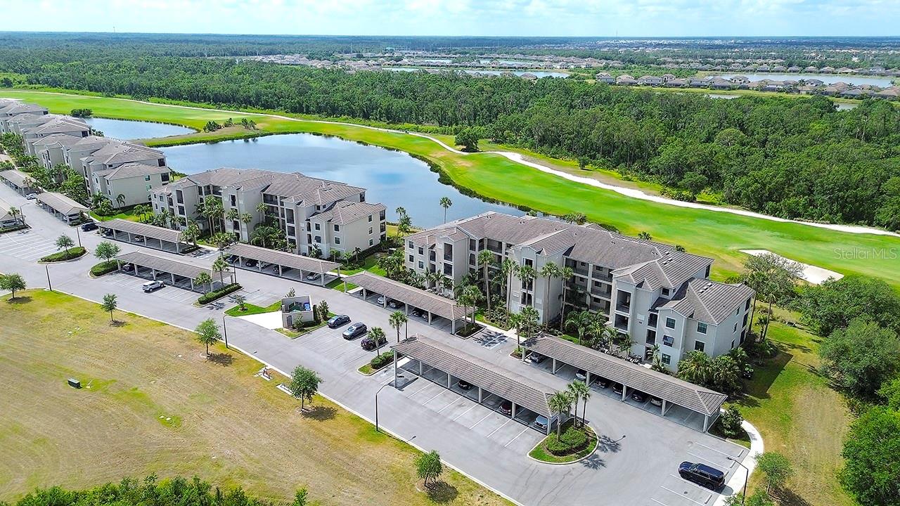 LIVE WHERE YOU PLAY and fall in love with this popular TURNKEY FURNISHED and GOLF INCLUDED Birkdale floorplan. Located securely within the gates of the coveted Lakewood National Golf and Country Club, the area is one of the top-rated master-planned communities in the country. This beautifully maintained two-bedroom, two-bath modern condo offers stunning views of the signature 16th hole on the Piper Course. With no building next door, you'll enjoy the privacy and unobstructed views of the lake and conservation area, plus breathtaking sunrises and vibrant sunsets from your private screened lanai. It's the perfect spot to relax and take in the natural beauty from morning to evening. Inside, you’ll discover thoughtfully designed living space showcasing a modern OPEN FLOOR PLAN and outstanding features including HURRICANE RATED high impact windows and doors for your protection and peace of mind, custom tile throughout the main living areas and LVP (luxury vinyl plank) flooring in the bedrooms offering elegance, durability and perhaps best of all…..NO CARPET! The gourmet kitchen serves as a stunning centerpiece, featuring a generous center island, pristine quartz countertops, solid wood cabinets, stainless steel appliances and ample space for both entertaining and everyday dining. The primary suite provides a serene retreat highlighted by quality furnishings, a spacious walk-in closet, and beautifully appointed en-suite bath with quartz vanity tops and a walk-in shower. Additional features include an assigned covered carport with ample guest parking, a private storage room conveniently located just outside the front door plus a Wi-Fi enabled thermostat, Schlage digital door lock and a Ring Doorbell for added security. Every detail has been carefully selected for modern, convenient and low-maintenance living. Lakewood National offers an ACTIVE FLORIDA LIFESTYLE beyond compare. Residents enjoy DEEDED GOLF MEMBERSHIP in 2- 18 Hole Arnold Palmer championship golf courses. The Grand Clubhouse features a main dining room, cocktail bar, veranda seating, private event spaces, and separate men’s and women’s locker rooms. Resort amenities include a beach style zero-entry pool with waterfall and lap lanes, a poolside tiki bar and café, a full-service spa, a state-of-the-art fitness center, eight Har-Tru lighted tennis courts, pickleball courts, bocce ball, and an action-packed social calendar curated by an on-site lifestyle director supported by a full team of professional instructors. It’s worth noting the current owners are the original owners occupying it only seasonally, non-smokers and do not own pets although pets are welcome. Lakewood National also has a progressive rental policy with transferable memberships, popular with seasonal renters, if generating income is of interest. Beyond the gates, you’ll find upscale shopping, fine dining, cultural attractions, world-class beaches, top-rated schools, and premier sports facilities just minutes away. Whether you’re looking for a full-time residence, a seasonal retreat, or a savvy investment opportunity, this impeccably designed home checks every box including the lock-and-leave convenience of maintenance free living. MAKE EVERYDAY FEEL LIKE A VACATION! Welcome home!