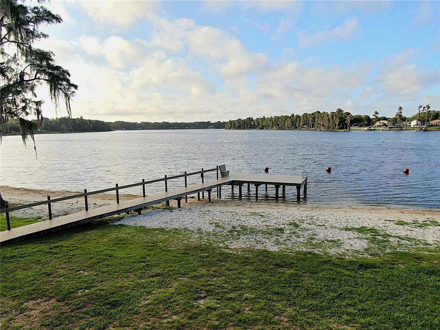 Discover Your Dream WATERFRONT PROPERTY on a CHAIN of 3 SKI SIZED LAKES
Welcome to an unparalleled opportunity to own a piece of paradise in a gated community that offers the finest in lakefront living. This large, waterfront lot is nestled in a park like community on not one, but three ski sized connected lakes, creating an aquatic haven for water sports enthusiasts and nature lovers alike. A perfect place for boating, water skiing, fishing, and kayaking. The property already includes a covered dock, well, septic tank, and drain fields.
This unique community designed for relaxation and recreation. Residents enjoy a private beach area complete with a boat ramp, Multiple docks, grills, picnic tables, sand volleyball court, horseshoes, and a designated swimming area. Whether you’re looking to spend a lazy afternoon basking in the sun or hosting a lively barbecue, this private beach area has it all.
Children will delight in the community playground, featuring a basketball court and ample space for play. The entire community is golf cart friendly, allowing for a leisurely ride through the picturesque surroundings, especially to the beach area and other amenity areas as well.
This idyllic community is dotted with majestic oak and cypress trees, creating a park-like atmosphere that invites you to connect with nature. As
you meander through the tree-lined streets, you'll appreciate the tranquility and beauty that defines this unique locale. The gated entrance ensures privacy and security, giving you peace of mind as you enjoy the numerous amenities.
One of the standout features of this property is that all impact fees have already been paid, streamlining the building process and saving you time and money. 
Whether you’re an avid boater, a fishing enthusiast, or simply someone who enjoys an active lifestyle, this community caters to all your recreational needs. The lakes are perfect for skiing, fishing, & kayaking, while the community spaces provide endless opportunities for outdoor fun. The convenience of the private boat ramp and fishing dock means you can easily indulge in your favorite water activities.
This community fosters a welcoming and vibrant atmosphere. Neighbors become friends at the beach area, children play together at the playground, and families gather for barbecues and picnics. The golf cart-friendly design encourages a sense of camaraderie as residents explore the community and enjoy the natural beauty together.
With its prime location on a three ski-sized lakes, this property is ready for you to build your dream home. Experience the lifestyle you’ve always envisioned—where every day feels like a vacation.
Schedule to see this property today