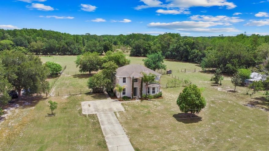 INTERIOR & EXTERIOR are being freshly painted…additional pictures to come. This is the quintessential neighborhood home, but down a country road on one full acre! Years ago, once part of the Florida Boys Ranch, this serene land was divided up among a large family. Rarely do these properties come on the market and at such a reasonable price point! After 40 years, this family is trading the peaceful life for a taste of the city! As I stood in the yard with the breeze sweeping across the neighboring pasture, the melodic hum of the cicadas, I asked “why?”. “Just a change they said.” The exact change YOU may be looking for, an escape, a slower pace, less rules…more animals! This beautiful part of Lake County is where Groveland “the city with natural charm” & Clermont “gem of the hills” seem to intertwine. A few minutes in either direction you have a change of address! This only adds to the everyday conveniences and daily commute. This home offers a large eat-in kitchen with an island. A partition does a great job at defining the spaces while still keeping it open to the great room. The formal dining room and large bonus room gives you plenty additional square footage for your individual preferences and needs. A primary suite could easily be created if a first floor bedroom is needed. The floors are tile downstairs and brand new carpet is being installed on the stairwell and 2nd level. A trending 2026 neutral paint color was chosen and looks fantastic! The foyer staircase leads to upstairs with a soaring 20 ft ceiling. The natural light radiates through the windows with nature views in every direction. The original floor plan has a partially open loft to the left, which has been enjoyed over the years as a play area as well as a bedroom, the choice is yours! All of the bedrooms are tucked on the 2nd floor adding to the cozy lifestyle. Heading outside, sliding doors lead to a covered and screened lanai that spans the entire back of the home. Enjoy entertaining year round with plenty of room for your hand crafted dining table and large outdoor sectional! Add a pool, fire pit, corn hole and playground and you will still have room to run in this massive fenced backyard! Something worth mentioning is the angelic sunsets in this area. The skies are painted nightly in vivid orange, pink & purple, followed by the pitch black night sky full of stars! This home alone is great, but having the ability to add on, grow and create more on this land is truly a smart move financially. THE NEIGHBORING HOME ON 5 ACRES IS ALSO AVAILABLE & HITTING THE MARKET IN JULY! Both of these homes are owned by the same family and would be ideal for people looking to enjoy 6 acres together! Living here you have easy access to area state forests, horseback riding trails, and the popular Van Fleet Trail or West Orange Trail. The small downtown area of Groveland has been flourishing with delicious international cuisine, fireworks at Lake David & new community traditions popping up every year! Historic downtown Clermont is just up the road featuring local restaurants, farmers markets, festivals, and lakeside recreation for all ages. Check out the North & South Chain of Lakes for fishing, boating and water sports! A new filtration system was just installed on the well and all kitchen appliances convey!