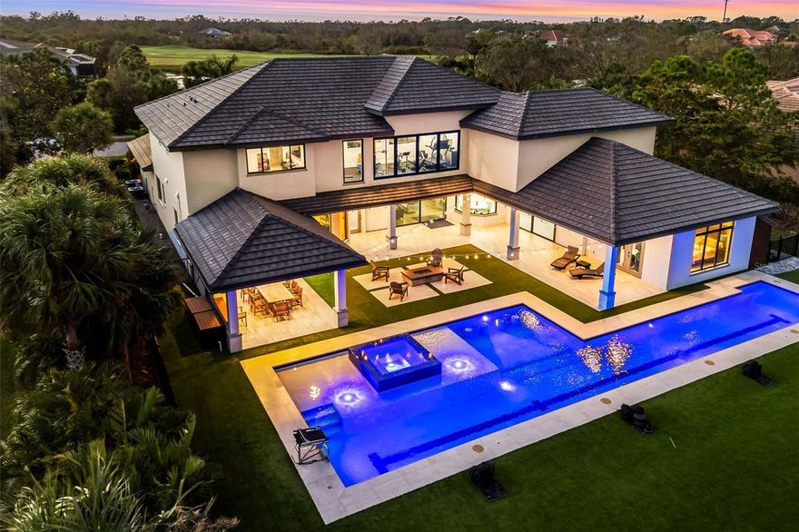 Modern luxury meets resort-style living in this 2022 custom estate in The Founders Club. With 7,149 sq. ft. of air-conditioned living space on an oversized 25,000+ sq. ft. homesite, this 5-bedroom residence delivers rare scale, privacy, and sophistication.

A dramatic glass-and-wood floating staircase and feature wine wall set the tone for the sleek interior, where soaring ceilings, designer lighting, and expansive glass showcase peaceful lake and preserve views. The gourmet kitchen features an oversized waterfall island, Wolf appliances, 2 dishwashers, custom cabinetry, and a fully equipped butler’s pantry with Miele coffee station. Flexible living includes two private offices, a home gym, and a dedicated theater.

Expansive sliding glass doors disappear to reveal an outdoor living sanctuary with a resort-style pool featuring a lap lane, sun shelf, raised spa, submerged seating, fire-pit lounge, and a covered lanai with fireplace and full summer kitchen. Full smart-home automation controls lights, climate, audio, security, and pool systems, supported by $250K+ in A/V upgrades and impact windows and doors throughout.
Additional highlights include a 4-car garage and modern architectural design inside one of Sarasota’s premier private golf communities, offering optional club membership and no CDD fees. 

Perfectly positioned for elite coastal living, a short drive away from Siesta and Lido Beaches, fine dining and luxury boutiques at St. Armands Circle, waterfront restaurants, golf, marinas, and the cultural venues of downtown Sarasota and let's not forget 10 just minutes away from Waterside, Lakewood Ranch and University Town Center. 

A rare modern estate offering next-level luxury and lifestyle in The Founders Club.