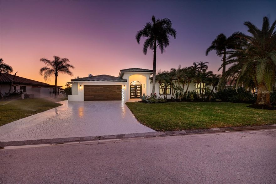 Welcome to the Million-Dollar Remodel in the prestigious waterfront community of Venetian Isles in Northeast St. Petersburg. This exceptional one-story waterfront pool home offers over 3,000 heated square feet of completely reimagined living space, featuring five bedrooms and four-and-a-half baths. The home has never flooded and delivers peace of mind along with elevated coastal luxury. From the moment you arrive, the curb appeal is extraordinary, showcasing premium wood-look soffits on all porches, a dramatic contemporary double-entry front door, custom modern wood-look garage doors, and a professionally finished epoxy-coated garage floor. Inside, a grand foyer stuns with a designer chandelier and curated lighting throughout, enhanced by abundant recessed LED lighting, illuminated LED vanity mirrors, and custom one-of-a-kind LED house numbers. The fully redesigned open-concept floor plan is ideal for both entertaining and everyday living. Luxury Malibu “Honey” wood-look tile flooring flows seamlessly throughout the home, complemented by porcelain tile feature walls, a striking living room fireplace with decorative flicker, half bath with gold tile accent, and custom Craftsman trim with solid-core doors throughout. The private office features a coffered ceiling detail, adding architectural sophistication.
The chef’s kitchen is a true showpiece with Cambria quartz countertops, enhanced custom cabinetry, and a professional-grade ZLINE Autograph Edition Monument Series appliance package, including a 60-inch French door refrigerator, double wall oven with microwave and convection, gas range with hood vent, dishwasher, and wet bar beverage refrigerator. A gas tankless water heater and gas fireplace provide modern efficiency and warmth. The luxurious primary suite offers a spa-inspired retreat complete with a freestanding soaking tub, oversized walk-in shower with sleek linear drains, and custom frameless glass enclosure. All bathrooms have been completely renovated with high-end finishes, designer tile selections, and quartz countertops. A newly added full cabana bath enhances poolside convenience.
Impact-rated sliding glass doors and windows provide security and energy efficiency while seamlessly connecting indoor and outdoor living. Step outside to a fully equipped outdoor kitchen overlooking the waterfront pool and beautifully redesigned landscape package. The refinished dock with electric boat lift offers easy access to deep-water canals and Tampa Bay, perfect for boating enthusiasts. The seawall was replaced in May of 2021. A zoned and programmable irrigation system maintains the lush grounds.
Additional upgrades include all new electrical and plumbing systems, new HVAC ductwork and venting with a fully serviced unit, and meticulous attention to detail throughout. Every element of this renovation reflects quality craftsmanship and thoughtful design.
Located less than 10 minutes from vibrant Downtown St. Petersburg, this home offers convenient access to the interstate, Tampa, Sarasota, premier dining, upscale shopping, and everything the St. Petersburg waterfront lifestyle provides. Venetian Isles is renowned for its deep-water canals, luxury homes, and prime Northeast location.
This is a rare opportunity to own a fully remodeled, move-in-ready, one-story waterfront masterpiece in one of St. Petersburg’s most coveted neighborhoods. Schedule your private showing today and experience modern coastal elegance at its finest.