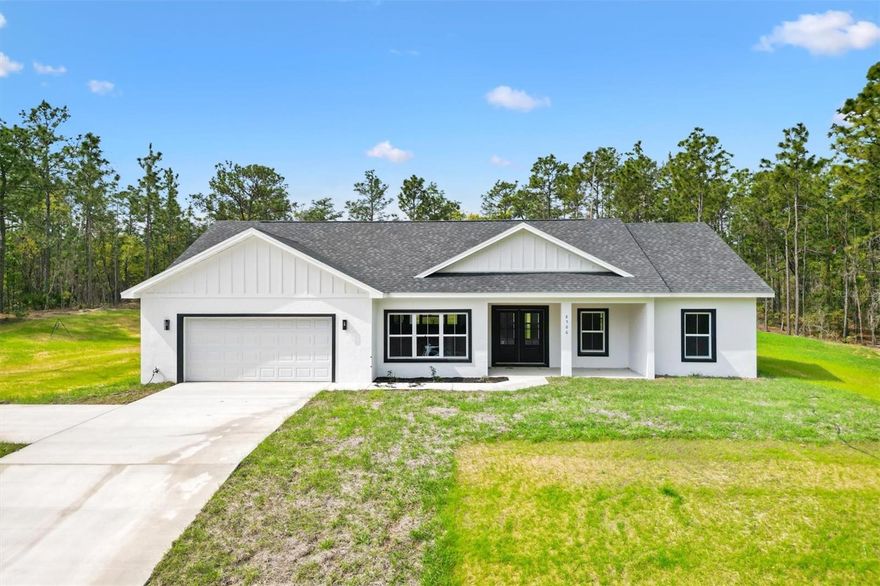 Welcome to this stunning modern farmhouse-style new construction home in the desirable Oak Hill subdivision of Wildwood, FL. Nestled in a quiet, rural setting on a spacious 1-acre homesite, this beautifully designed 3-bedroom, 2-bath home with a den/office offers the perfect blend of privacy and convenience. Enjoy peaceful country living while being just minutes from The Villages, top-rated schools, shopping, dining, and more. Built with block and stucco construction, this home delivers durability, energy efficiency, and low-maintenance living for years to come. Offering 1,906 square feet of living space, the thoughtfully designed floor plan includes an oversized garage, covered rear lanai, and an interior laundry/mud room. Step inside to an inviting open-concept layout featuring high ceilings, luxury vinyl plank flooring, recessed lighting, and 5” baseboards, all wrapped in a clean, modern aesthetic. The kitchen serves as the heart of the home, showcasing a large center island, Farmhouse Single Basin sink, custom wood cabinetry, stainless steel appliances, under-cabinet lighting, tile backsplash, walk-in pantry, and a cozy dining nook—perfect for everyday living and entertaining. The primary suite is a true retreat with a spacious walk-in closet and a spa-inspired ensuite featuring a freestanding soaking tub, walk-in tiled shower, and ample cabinet space. The secondary bedrooms are generously sized with walk-in closets and share a well-appointed guest bath with a tiled shower. The den/office offers flexible space ideal for a home office, media room, or even an additional bedroom. Outside, the property continues to impress with its expansive lot and serene surroundings—no expense was spared in creating this beautifully crafted home. This is a rare opportunity to own a brand-new home with space, style, and location all in one. Schedule your private tour today—this one won’t last!