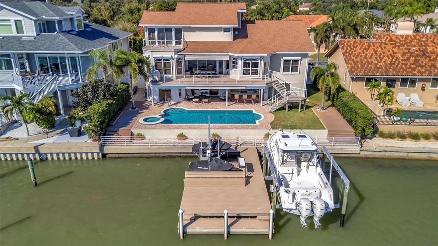 Motivated Seller! Welcome to a true waterfront paradise offering spectacular, unobstructed open bay views—the ideal setting for the Florida lifestyle, perfect for kayaking, swimming, and quiet enjoyment. Discover unparalleled luxury in this exquisite, fully renovated waterfront estate nestled within a spectacular GATED COMMUNITY. Enjoy the beautiful amenities of the renowned Pasadena Yacht & Country Club, all while benefiting from an incredible location with less than a 15-minute commute to vibrant Downtown St. Pete! This estate has been renovated top-to-bottom and offers 5 spacious en-suite bedrooms plus a 1/2 bathroom, providing comfort and privacy for all. The exterior boasts an entertainer’s dream with an extended deck overlooking the bay, a resurfaced pool, and a brand new, unused pool bar area. This ultimate outdoor kitchen features two new refrigerators, a dedicated ice maker, dishwasher, and a 3-tap system for premixed beverages. The waterfront is ready for your toys with a new dock system featuring a confirmed 16,000 lb fully loaded boat lift and a separate lift for two jet skis. Anglers will appreciate the brand new installed fish cleaning station with a dedicated water line. Inside, the home is appointed with the highest level of luxury finishes. The flooring is brand new throughout, featuring elegant new carpet and premium luxury vinyl plank (LVP). The living room offers a grand scale with high ceilings, complemented by tasteful Hunter fans and high-end Moen fixtures in the baths. Every bathroom features the exquisite Cambria Brittanica Quartz from the Luxury Collection. The gourmet kitchen is equipped with top-of-the-line KitchenAid appliances (including a new dishwasher), and the laundry room features the largest capacity Samsung washer and dryer set available. Practical amenities abound, including a 4-car garage that is convertible to 5-car capacity for the collector or enthusiast. Crucially, the home features a dedicated craft room—completely separate from the bedrooms and den—offering an invaluable space for hobbies without sacrificing a bedroom. The primary suite is a true retreat, featuring a large walk-in closet and a convenient wet bar area with a fridge and sink. This is not just a house; it's a completely renovated, ready-to-enjoy luxury compound.