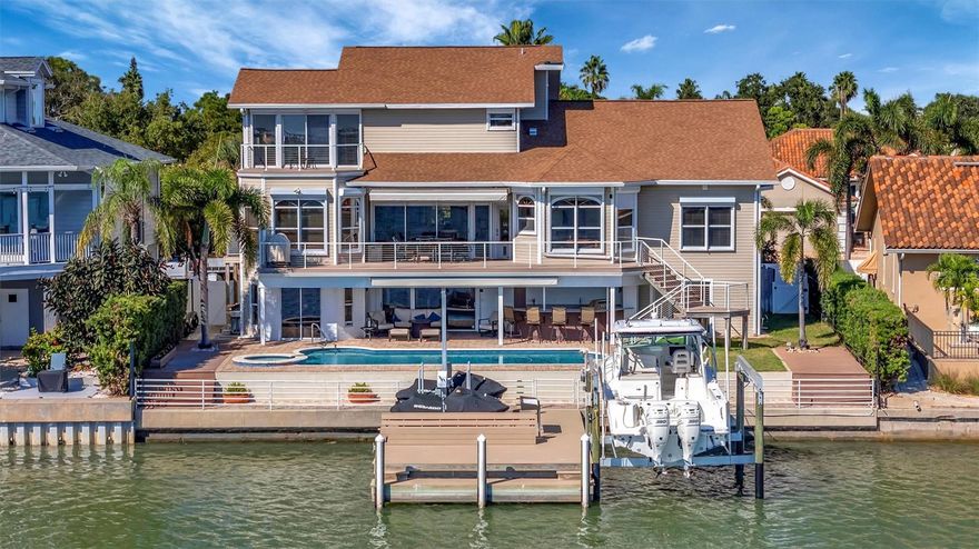 Welcome to a true waterfront paradise offering spectacular, unobstructed open bay views—the ideal setting for the Florida lifestyle, perfect for kayaking, swimming, and quiet enjoyment. Discover unparalleled luxury in this exquisite, fully renovated waterfront estate nestled within a spectacular GATED COMMUNITY. Enjoy the beautiful amenities of the renowned Pasadena Yacht & Country Club, all while benefiting from an incredible location with less than a 15-minute commute to vibrant Downtown St. Pete! This estate has been renovated top-to-bottom and offers 5 spacious en-suite bedrooms plus a 1/2 bathroom, providing comfort and privacy for all. The exterior boasts an entertainer’s dream with an extended deck overlooking the bay, a resurfaced pool, and a brand new, unused pool bar area. This ultimate outdoor kitchen features two new refrigerators, a dedicated ice maker, dishwasher, and a 3-tap system for premixed beverages. The waterfront is ready for your toys with a new dock system featuring a confirmed 16,000 lb fully loaded boat lift and a separate lift for two jet skis. Anglers will appreciate the brand new installed fish cleaning station with a dedicated water line. Inside, the home is appointed with the highest level of luxury finishes. The flooring is brand new throughout, featuring elegant new carpet and premium luxury vinyl plank (LVP). The living room offers a grand scale with high ceilings, complemented by tasteful Hunter fans and high-end Moen fixtures in the baths. Every bathroom features the exquisite Cambria Brittanica Quartz from the Luxury Collection. The gourmet kitchen is equipped with top-of-the-line KitchenAid appliances (including a new dishwasher), and the laundry room features the largest capacity Samsung washer and dryer set available. Practical amenities abound, including a 4-car garage that is convertible to 5-car capacity for the collector or enthusiast. Crucially, the home features a dedicated craft room—completely separate from the bedrooms and den—offering an invaluable space for hobbies without sacrificing a bedroom. The primary suite is a true retreat, featuring a large walk-in closet and a convenient wet bar area with a fridge and sink. This is not just a house; it's a completely renovated, ready-to-enjoy luxury compound.