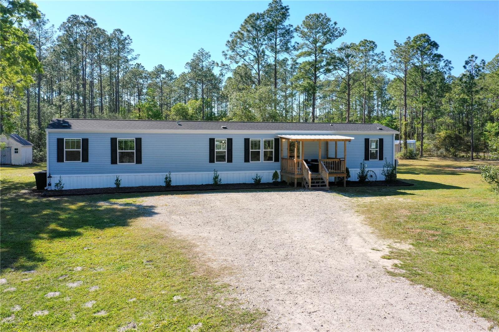 This beautiful 2023 mobile home is move-in ready and situated on a spacious acre with a paved road. Designed with a modern, finished-drywall look, the open-concept layout offers three bedrooms and two bathrooms with stylish wood-look linoleum flooring throughout—no carpet anywhere.
The island kitchen is both functional and elegant, featuring 36-inch white cabinets with crown molding, stainless steel appliances, a decorative hood vent and bar seating. The adjoining living room is spacious and inviting, with crown molding that extends throughout the entire home.
The main suite is a private retreat, complete with a luxurious bathroom that includes double vanities, a separate soaking tub and shower, and a walk-in closet. Two additional guest bedrooms are well-sized and share a nicely appointed bathroom. The indoor laundry room is generously sized and comes equipped with a washer and dryer.
Significant updates in 2023 include a brand-new water filtration system, pump, and electrical work. The septic and drain field were also serviced with electrical updates. A 10x10 storage unit provides extra space, and a transferable termite bond through Massey Pest Control offers peace of mind. The home is surrounded by gutters for efficient drainage, and the newer 10x12 covered front patio is perfect for outdoor relaxation. The property is partially fenced and equipped with two doorbell cameras for added security. With underground cable and internet already in place, staying connected is effortless.
Most importantly, this property has never flooded, and the roads leading to it have remained dry. Offering modern features, thoughtful upgrades, and a prime location, this home is truly a must-see. Schedule your showing today!