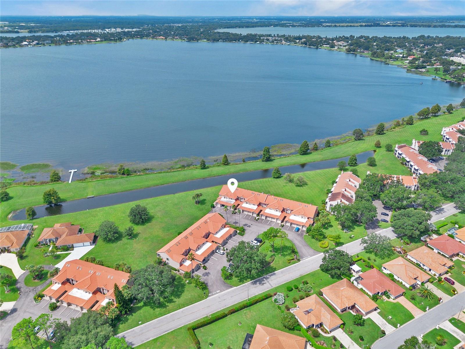 Elevated waterfront views, nightly sunsets, and direct access to the world-famous Winter Haven Chain of Lakes—welcome to this beautifully updated condo in the gated lakeside community of Winterset. Offering 2 bedrooms, 2 bathrooms, and its own private one-car garage, this residence blends comfort, style, and the relaxed Central Florida lakefront lifestyle.
Step inside to discover an open and inviting layout with high ceilings and an airy feel unique to second-floor living. The great room is the heart of the home, featuring newer carpeting, updated lighting, and expansive glass sliders that frame panoramic views of Lake Winterset while filling the space with natural light from the skylights above.
Adjacent to the living area, the generous dining space flows easily into a well-designed eat-in kitchen. Here you’ll find a breakfast bar, dinette, painted cabinetry, closet pantry, laundry closet with washer and dryer, and a full suite of updated stainless appliances—including a gas range, refrigerator, dishwasher, and microwave.
The primary suite is a true retreat, offering tranquil lake views, private lanai access, and an expansive walk-in closet. The en-suite bath includes an extended vanity with sitting area and a beautifully updated walk-in shower. Split from the primary, the guest bedroom is generously sized with ample closet space and private en-suite access to the second full bath, which features a new marble-topped vanity and a tub/shower combination.
Most updates have been completed within the past 2.5 years, including new carpeting, light fixtures, blinds, closet doors, guest bath vanity, water heater, updated electric panel, and a new AC system—ensuring modern comfort and true move-in readiness.
The screened balcony provides a private outdoor escape, perfect for morning coffee, evening breezes, or magical sunsets over Lake Winterset. A one-car garage offers secure parking and extra storage, with additional guest parking conveniently nearby.
Life in Winterset means enjoying one of Winter Haven’s most sought-after lakefront communities. Amenities include a lakeside clubhouse, pool, hot tub, tennis and pickleball courts, shuffleboard, and a private boat ramp, all set among meticulously landscaped grounds ideal for evening walks or bike rides. From the community ramp, you’ll have direct access to the Winter Haven Chain of Lakes—more than 20 interconnected lakes renowned for boating, fishing, skiing, and waterfront dining.
Beyond the gates, Winter Haven offers a vibrant lifestyle with a quaint downtown full of weekend markets, breweries, boutiques, and craft cocktail lounges. Lakeside dining, cultural events, and year-round community activities make every weekend feel special. Centrally located in the heart of Florida, Winter Haven provides an inland setting insulated from coastal flooding, a more affordable cost of living and insurance, and convenient access to Tampa, Orlando, and world-class attractions.
Situated off Cypress Gardens Boulevard, Winterset is just minutes from Publix, Walmart, Legoland, shopping, dining, medical facilities, and major highways—making daily life effortless.
This is a rare opportunity to embrace Central Florida’s legendary Chain of Lakes lifestyle while enjoying the comfort and charm of Winter Haven living.