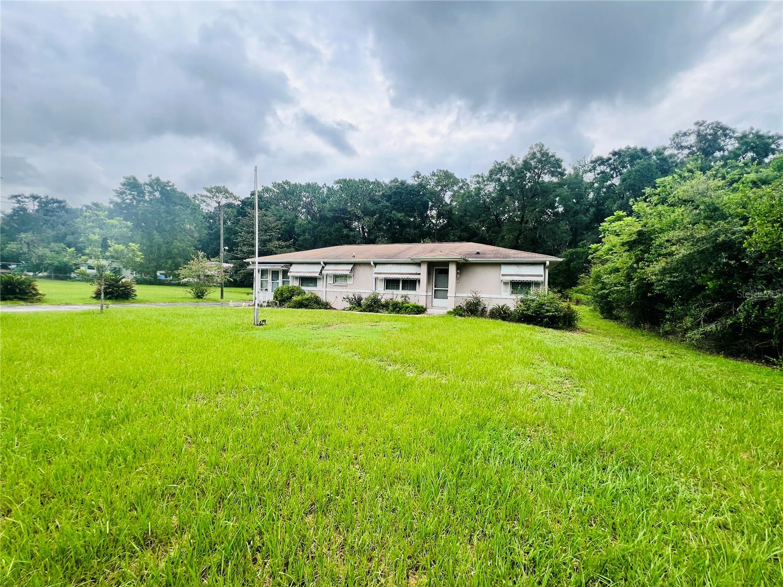 Great 2/2 home located in between Belleview and Ocala. Home is solid concrete block construction on a 1/2 acre of land, with loads of potential! The sale only includes the lot the home is on, and not the attached additional lot inside of the fenced area.