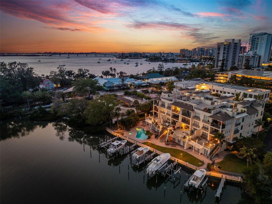Tucked along the shimmering waterfront in the heart of Sarasota, Hudson Crossing is an exclusive enclave of just twelve residences, offering an exceptional balance of privacy, sophistication, and walkable convenience. Perfectly positioned across from the beautifully revitalized Marie Selby Botanical Gardens, this coveted address places you moments from the bayfront, world-class dining, and a vibrant arts and cultural scene—while still preserving a tranquil, residential ambiance. This refined three-bedroom waterfront residence lives with the scale and comfort of a single-family home, paired with the effortless luxury of condominium living. Thoughtfully curated for both lifestyle and function, the home includes a private two-car garage, ground-level storage, a deeded boat slip, and a rare, exclusive rooftop terrace—an offering seldom found in such a premier downtown setting. Spanning over 2,500 square feet, the interiors are impeccably maintained and designed for immediate enjoyment. High ceilings and elegant tile flooring set the tone for the light-filled, open-concept layout, ideal for both relaxed living and sophisticated entertaining. At the heart of the home, a chef-inspired kitchen showcases custom cabinetry, premium stainless steel appliances including Wolf, Bosch, and Sub-Zero, a gas cooktop, walk-in pantry, and an expansive breakfast bar that seamlessly connects to the main living areas. Walls of impact-rated sliding glass doors frame the living and dining spaces, opening to a waterfront terrace that blurs the line between indoors and out. Here, tranquil water views and gentle coastal breezes create a serene backdrop for everyday living. The primary suite serves as a private sanctuary, complete with terrace access, two spacious walk-in closets with custom built-ins, and a luxurious ensuite bath beautifully appointed bath with quartz finishes and a large soaking tub. Two additional guest suites are thoughtfully positioned for privacy, each offering walk-in closets and flexibility for use as guest accommodations, a home office, or a refined library. In addition to the private 2-car garage with EV hookup, built-in cabinetry, and bike storage, this residence includes a large private storage cabana near the pool and dock, providing ample space for kayaks, fishing gear, and more – a rare feature that outdoor enthusiasts will love. For boating enthusiasts, the deeded dock with 20,000 lbs. boat lift provides direct access to Sarasota Bay, with effortless navigation to downtown landmarks such as the Ringling Bridge. Kayak down to Marina Jack or sail to Big Pass and New Pass in just minutes, with seamless passage to the Gulf and its renowned beaches. Hudson Crossing represents a rare opportunity to experience a low-density, waterfront lifestyle in one of downtown Sarasota’s most desirable locations—just moments from the Bayfront, theaters, galleries, boutiques, the weekly farmers market, and the area’s celebrated white-sand shores.