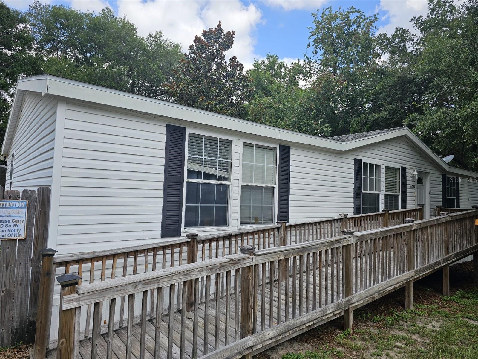 3 bedroom 2 bath doublewide mobile home. Home is a 2003 model with 1674 sq feet of living. Property offers a handicap wood ramp on the front of the home along with a fenced back and side yard. 2 car carport (24 X 20) attached to the front of a 24 x 20 Workshop/ storage room. Home features a large living room and a large family room with fire place and built in entertainment center. Kitchen features lots of cabinet and counter space with a center island with your sink area and a area for a dishwasher and features a eat in bar area on the back side of island.
This home must be a cash deal. Major leak in the Primary bathroom and laundry area. All vinyl flooring in bathroom and laundry have been pulled up. Primary bathroom floors, cabinets and drywall behind sinks have been removed. Laundry room has soft flooring and some drywall have been removed. Floors are soft in this area. Soft spots in primary bedroom, family room, Livingroom, a few spots in kitchen. Dining room slider has some wall damage an back porch decking has been removed and needs to be replaced before you can exit out the slider. Supra box is on front door key goes to back storage building also.