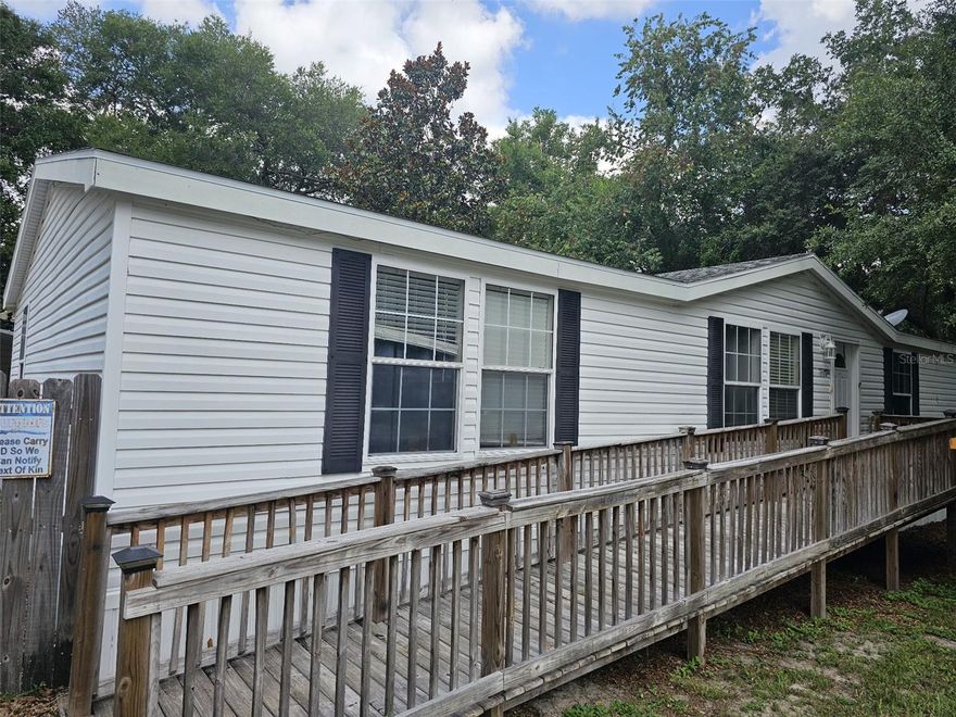Short Sale. This home is now listed as a short sale. Please bring offers to present to the lender.  3 bedroom 2 bath doublewide mobile home. Home is a 2003 model with 1674 sq feet of living. Property offers a handicap wood ramp on the front of the home along with a fenced back and side yard.  2 car carport (24 X 20)  attached to the front of a 24 x 20 Workshop/ storage room. Home features a large living room and a large family room with fire place and built in entertainment center. Kitchen features lots of cabinet and counter space with a center island with your sink area and a area for a dishwasher and features a eat in bar area on the back side of island.
This home must be a cash deal. Major leak in the Primary bathroom and laundry area. All vinyl flooring in bathroom and laundry have been pulled up. Primary bathroom floors, cabinets and drywall behind sinks have been removed. Laundry room has soft flooring and some drywall  have been removed. Floors are soft in this area. Soft spots in primary bedroom, family room, Livingroom, a few spots in kitchen. Dining room slider has some wall damage an back porch decking  has been removed and needs to be replaced before you can exit out the slider. Supra box is on front door key goes to back storage building also.