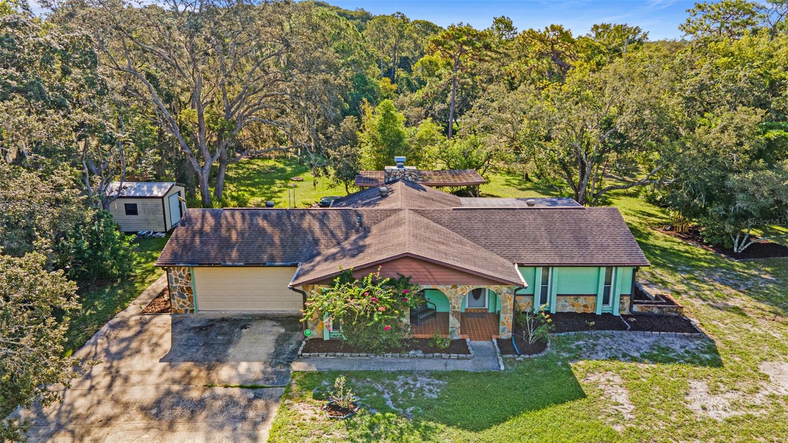 Check out this cute, country style home with 3 bedrooms, 2.5 bathrooms, 2-car garage, right under 1 acre with NO HOA!! PAVED ROAD AND A CORNER LOT!! Located in a HIGH & DRY area with ER Zoning. Surrounded by custom single family homes. This is a VERY private location, just off State Rd 52, with no through traffic. There are only two streets so rest assured you should expect - peace and quiet. This home sits in a park like setting where there are plenty of trees and shade. Separate Living Area and Den with a Wood Burning Fireplace. Split Bedroom Floor Plan that is perfect for family and/or guests that visit. Step out onto your covered screened-in patio to enjoy your morning coffee and those warm Florida days! Kitchen Reverse Osmosis System Installed. Upgrades Include: Well Pump 2017, Garage Door Opener 2019, Refrigerator 2022, Dishwasher 2024, Roof 2010, HVAC 2013, Windows 2011, Metal Storage Shed. Total Square Footage is right under 2,300 square feet. Oversized Garage right under 500 square feet with workshop space. NO FLOOD ZONE!! Be at TPA International Airport in less than 35 minutes on the Suncoast Parkway. Less than an hour drive to St Petersburg.