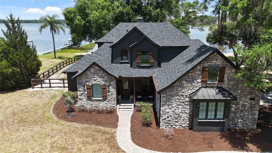 Experience the best of Central Florida lakefront living on Trout Lake, part of the Alligator Chain of Lakes, with this exceptional custom-built home located at 6805 Bass Highway in St. Cloud. Offering a rare combination of luxury, privacy, and investment potential, this stunning waterfront property is perfectly suited as a primary residence, second home, or vacation rental — all with NO HOA restrictions.

Ideally positioned within one hour of Walt Disney World Resort and Universal Orlando Resort, Orlando’s world-famous attractions, and Florida’s beautiful east coast beaches, and just 30 minutes from Lake Nona and the Orlando International Airport this property offers the perfect balance of peaceful lakefront living and convenient access to everything Central Florida has to offer.

Built in 2014, this impressive 3,535-square-foot custom home features 4 bedrooms, 4 bathrooms, and thoughtfully designed living spaces filled with high-end upgrades and custom details throughout. From the moment you enter, you’ll appreciate the upgraded cabinetry, premium countertops, designer fixtures, upgraded flooring, and beautifully finished stained concrete surfaces that create a warm yet modern lakefront aesthetic.

The spacious chef’s kitchen was designed with both functionality and entertaining in mind, featuring extensive custom cabinetry and an expansive hidden walk-in pantry that provides exceptional storage and organization. Throughout the home, you’ll find numerous built-in storage areas, window seats in most bedrooms, and carefully crafted details that add both charm and practicality.
The primary suite offers a luxurious private retreat complete with a dedicated vanity/glam room and generous storage solutions. Upstairs, a versatile bonus room provides endless possibilities and can easily function as a home office, media room, playroom, or be converted into an additional bedroom.

Additional flexible living spaces include a separate air-conditioned room ideal for a home gym, hobby room, or flex space, along with a dedicated air-conditioned laundry room conveniently located off the garage. The property also includes multiple outdoor storage sheds, offering even more room for tools, lake toys, and equipment.

Set on 160 feet of fully cleared lakefront, the property showcases breathtaking water views, a private sand beach area, and direct access to the highly sought-after Alligator Lake Chain — a connected chain of five lakes known for boating, fishing, and watersports.
The outdoor amenities are truly exceptional. A brand-new 110-foot dock features a covered metal roof, electric boat lift, lakeside sitting area, and propane fire pit, creating the ultimate waterfront gathering space. The expansive 600-square-foot fully enclosed screened outdoor kitchen overlooks the lake and offers year-round enjoyment for entertaining family and guests. An additional lakeside fire pit area further enhances the unmatched outdoor lifestyle this property provides. 

Major recent upgrades include a roof and exterior paint both completed just 2 years ago, adding long-term value and peace of mind.

This is a rare opportunity to own a true Central Florida lakefront lifestyle property with freedom, luxury, space, and exceptional vacation rental potential!