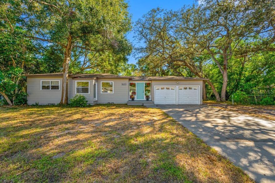 Beautiful home in the residential area next to Crest Lake Park.  This home features a rare DOUBLE LOT 100 X 137 deep. This is the perfect 1 story single family home 3 full bedrooms and a huge light filled living room perfect for entertaining.  Home also features an extra large 2 car garage and big driveway.  Entering the home you are greeted with a spacious foyer that has views into your kitchen and  the ENORMOUS living room which stretches 32 feet long with beautiful wood beams and a wood burning fireplace. Just off of this room is your kitchen redone in 2023 featuring stainless steel appliances and a window that has views into your large backyard. Your bedrooms are down the left wing of the home which enjoys original hardwood floors. A/C and ducts 2023,  Water heater 2023, newer roof. Just add your final touches!  As a bonus this home comes with a bath in the garage. Shower stall on the left and toilet on the right. Crest Lake Park is within view of your home has dog parks, walking/jogging trails, volleyball courts, fishing, splash pad, playground, pavilions, and more. Conveniently located just off Gulf to Bay or 60, you are just a few miles from the World-Famous Beaches of Clearwater and adjacent to downtown. Come see this double lot property in the heart of Clearwater and everything it has to offer today!