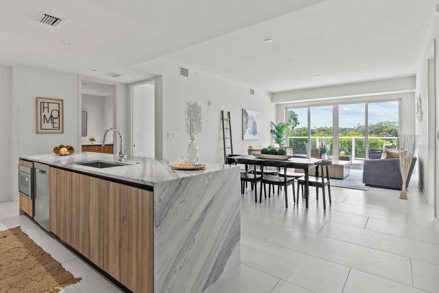 An incredible value at the renowned Serena by the Sea! Discover refined luxury coastal living at Serena with approx. 23,000 SF of resort-style amenities and 24-hour concierge. This convenient first-floor residence is elevated above street level and offers 1,420+/- sq ft of interior space, plus an expansive 489+/- SF private terrace, with southern exposure overlooking Stevenson Creek. Enjoy watching the dolphins, manatees, and other marine life play in the water from your open-concept kitchen, appointed with high-end stainless steel Gaggenau appliances, including a 5-burner gas cooktop, French door refrigerator, built-in oven, microwave, and dishwasher. A large waterfall quartz island anchors the space with spacious breakfast bar, paired with custom-made Italian cabinetry and additional lighting upgrades for functionality and visual appeal. Porcelain marbled tile flooring spans the entire interior living spaces and terrace. Two sliding glass doors open from the bright living room to the private terrace. The owner’s suite features a spacious bedroom with sliding glass door offering direct access to the terrace and south-facing water vistas. Its ensuite bathroom boasts a frameless glass enclosed rainfall shower and floating double vanity. The guest bedroom has floor-to-ceiling windows and is adjacent to the second full bathroom including a tub with shower. The dedicated laundry room offers hookups for washer & dryer is conveniently located next to the kitchen. Residents have access to the professionally designed resort-style amenities, including a heated saltwater pool overlooking Clearwater Bay, poolside cabanas and summer kitchens with grills, a wellness spa, sauna, fitness center, and social lounge. Serena by the Sea is a one-of-a-kind gated, boutique luxury condominium located in Clearwater, just minutes from the world-famous Clearwater Beach and Downtown Dunedin, convenient to St. Petersburg & Tampa, and approx. 18.5 miles to Tampa International Airport. Come tour this one today!