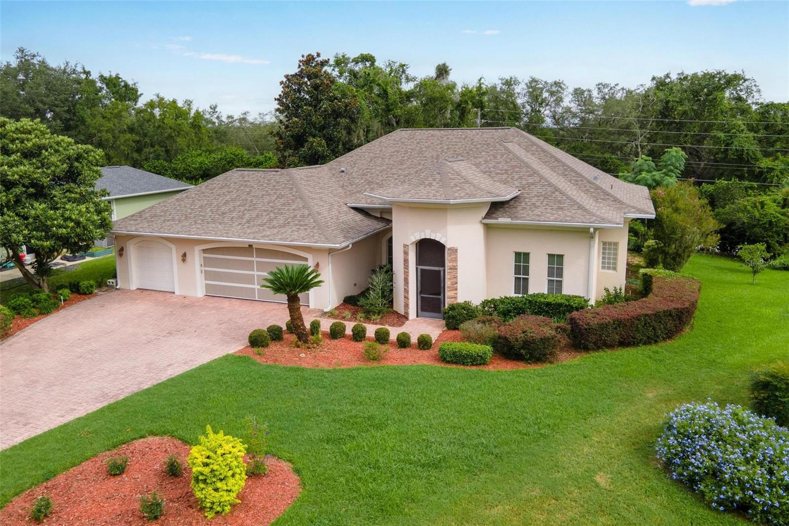 THREE CAR GARAGE…MOVE IN READY! Enjoy coming home to this quiet, guard gated community within minutes to The Villages! No bonds and no hassle living in this desirable golfing community with sidewalks for your walking pleasure!! Clubhouse with pool and with amenities available for a separate fee! Lot’s of parking on your brick paver driveway that lead to the newly screened in front porch! The huge great room with separate dining area include the Chandelier and feature High Ceilings with crown molding! Enjoy the spacious kitchen with newer appliances to include a double oven smooth top range, side/side refrigerator, dishwasher & disposal plus built in microwave. Inside laundry room with cabinets make doing this chore a pleasure…You will love your primary bedroom that includes two separate walk-in closets plus glass sliding doors leading to your 41 foot long screened in birdcage! End your day in your “spa-like” bathroom that includes a soaking tub with jets, separate walk in shower with bench seat, dual raised vanities & water closet for privacy!! Split plan design, your guests will love…bedrooms 2 & 3 with large wall closets share the guest bath. This amazing bathroom includes a shower plus hand held option and a walk in tub with jets for relaxation! Back porch under lanai could easily be enclosed for additional living space…HURRY. HURRY. HURRY…WON’T LAST!!