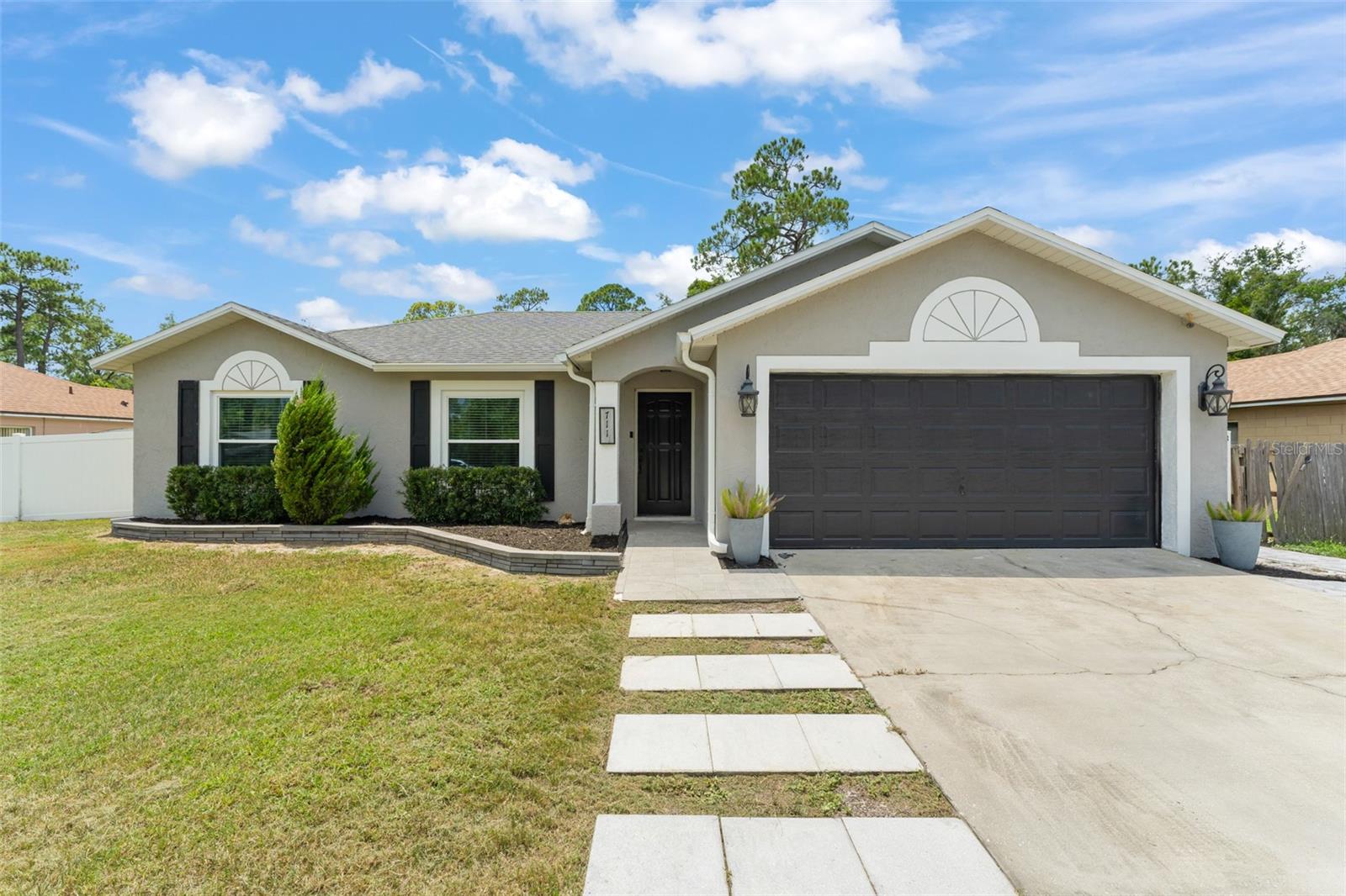 **This house comes with a REDUCED RATE through the seller's preferred lender. This is a lender-paid rate buydown that reduces the buyer's interest rate and monthly payment.** Tucked away on a nearly quarter-acre lot in the heart of Deltona, this beautifully updated 3-bedroom, 2-bathroom home offers nearly 1,200 square feet of thoughtfully designed living space, all wrapped in a sophisticated modern gray exterior that hints at the elegance awaiting inside. From the moment you step through the front door, you’ll be captivated by the seamless flow of the open living, dining, and kitchen areas. The living room invites you in with a cozy built-in electric fireplace, complete with a custom mantel and a charming wall niche with shelves—perfect for displaying your favorite décor. A stylish chandelier adds a touch of sophistication to the dining space, setting the stage for intimate meals or lively gatherings. The heart of the home—the kitchen—is a true showstopper. Crisp white cabinetry is paired with luxurious quartz countertops and a matching backsplash, creating a bright and welcoming space. A center island provides additional prep space and seating, while stainless steel appliances and a sliding glass door to the backyard complete this modern culinary haven. The split floor plan ensures privacy, with the primary suite tucked away at the rear of the home. This serene retreat features a spacious walk-in closet with built-in shelving and a spa-inspired ensuite bathroom. A stunning overhead rain shower, floor-to-ceiling tile in a sleek white, gray, and black palette, and a tray ceiling elevate the space, while a barn-style glass door adds the perfect modern touch. Laminate flooring runs throughout the home, tying each room together with warmth and durability. On the opposite side of the home, you'll find two additional bedrooms with built-in closets and a second full bathroom adorned with elegant tilework and a contemporary vanity. Step outside and discover your own private oasis. The fully fenced backyard is a blank canvas with pavers creating a versatile outdoor living space—ideal for relaxing, entertaining, or letting your creativity shine. Follow the pavers to a converted shed, now a functional flex space complete with laminate flooring, a ceiling fan, and a mini-split AC unit—perfect for a home office, studio, or guest retreat. 711 Cloverleaf Blvd is more than just a house—it's a place to call home. Schedule your private tour today and fall in love with every thoughtful detail. Recent upgrades for peace of mind and long-term value include: Roof 2020, AC 2021, Windows 2022, Converted Shed 2022, and Pavers 2022.