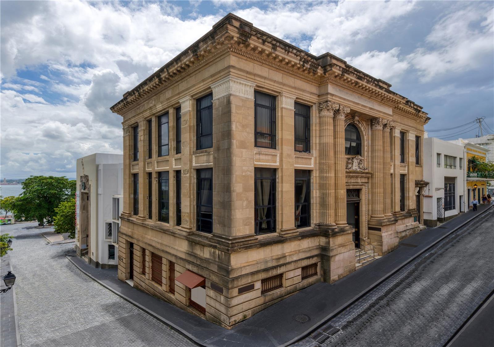 ***SOLD*** Situated in the heart of Old San Juan, 204 Tetuan stands as a testament to the city's rich history and architectural grandeur. Originally constructed in 1912 as a distinguished bank building, this property exudes timeless elegance with its magnificent stone facade and imposing 16-foot ceilings in the entrance hall. Upon stepping inside, one is greeted by the impeccably preserved original marble columns and flooring, a captivating reminder of the building's prestigious past. Descending to the lower floor unveils a fascinating feature—a former bank vault, presenting an exciting opportunity for conversion into a wine cellar or a captivating focal point within the home. The third floor, with its expansive open space, offers versatility and potential, ideal for crafting bedrooms that boast enchanting views overlooking Tetuan Street, with each floor boasting its own separate entrance. Moreover, the property's commercial zoning adds to its appeal, allowing for various possibilities to suit the discerning buyer's preferences and needs. For those seeking to weave their own narrative into the tapestry of Old San Juan's storied past, 204 Tetuan presents an unparalleled opportunity to transform a piece of history into a cherished residential sanctuary. Old San Juan is the epicenter of Puerto Rican culture and is dotted with several UNESCO World Heritage Sites. It serves as one of the top tourist destinations in the Caribbean and its celebrated buildings are renowned for their elegance and cultural significance. The area is known for its numerous dining, shopping and nightlife options. Minutes away from Condado Beach and the Miramar Arts Districts. Walk along the cobblestone streets and experience the mesmerizing vibrancy of what we call El Viejo San Juan.