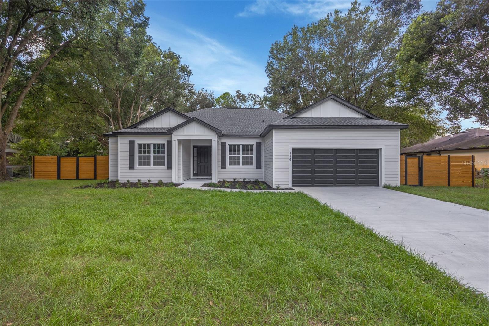 This CUSTOM built 5/3 PLUS OFFICE is stylishly and thoughtfully designed to compliment your Florida lifestyle. You will be impressed as you drive up to this stunning home bursting with curb appeal. Enter to volume ceilings towering over bright, airy sight lines allowing the natural light to flow throughout the entire home. This open concept design highlights a chef's kitchen, complete with soaring cabinetry made to sparkle with accent lighting on glass second tiered uppers and above workspace to light up your culinary creations! The statement island and designer hood both finished in deep warm tones along with the stainless appliances, pull out microwave and stylish quartz countertops give this home it's unique upmarket feel. The primary affords king space with a beautiful ensuite. Enjoy dual vanities, luxurious glass enclosed shower, back-lit/front-lit mirrors, two linen closets and generous walk-in closet. Who will get the office? With two secondary bedrooms on the north side and two on the south side each sharing a bath, there are enough rooms to consider taking up a hobby. Maybe sewing or a crafting? Tile and finishing choices throughout the home are exceptional! Step outside on the lanai and appreciate a half acre of peacefulness. Nicely treed yard with handy pole barn. Whole house water filtration system. Think of the possibilities! NO HOA! NEW, NEW, NEW!