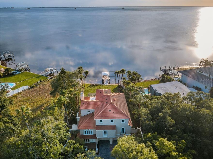 A masterful achievement of concept and design, enjoy breathtaking unparalleled unobstructed wide-open-water views of the Gulf of Mexico. Reminiscent of a Tuscan Estate this 3-story waterfront residence is truly an oasis of serenity, breathtaking waterway views from most every room. 3-bedroom + den, 3.5 bath pool home with a private dock & fishing pier is ideal for the avid fisherman & boat enthusiast! Sits on a 14,366 sqft gated lot, 88 feet of Gulf frontage. Lushly landscaped gardens, circular paver driveway & walkway. This home boasts an open great room with fireplace, beamed ceilings, porcelain tile floors, double panel tinted & insulated sliding glass doors that open onto the screened porch patio overlooking the Gulf of Mexico. Cozy den or game room which is a perfect work retreat; cathedral v-groove beamed ceilings. The culinary eat-in kitchen has white stacked cabinets, high bar, walk-in pantry, 6-burner gas range, double ovens, ice maker, cabinet storage, walk-in pantry. Enjoy entertaining in the grand formal dining room: cathedral ceiling, built-in Butler's pantry, snack bar. 2-secondary bedrooms share a jack-n-jill bathroom: 2-sink granite top vanity, glass door walk-in shower. Powder room. The entire 3rd-floor is the master suite. Private screen enclosed veranda which boasts spectacular sunsets with views of the Gulf, perfect location for a night cap! His & Her separate bathrooms, jetted tub and shared walk-in shower, His & Her walk-in closets. Serene adjacent in home office: built-in desk work center, shelves with Gulf views. The laundry room is huge and offers plenty of air conditioned storage. The walled backyard has a double gate for boat/trailer access, privacy prevails. Sprinkler reclaimed water. 6-year new clay tile roof. Concrete foundation with pre-stressed concrete pilings driven down to rock according to the previous owner who built this magnificent home. Palm Harbor boasts 210-acre Wall Springs Park including a natural spring, minutes to the Sponge Docks, Pinellas county trail & highly rated restaurants. Minutes to the Tampa International Airport. Zoned Palm Harbor University High School. Featured Home "Beach Hunters" Florida Dream Home with West-Facing Views (TV Episode 2019). EV ready.
