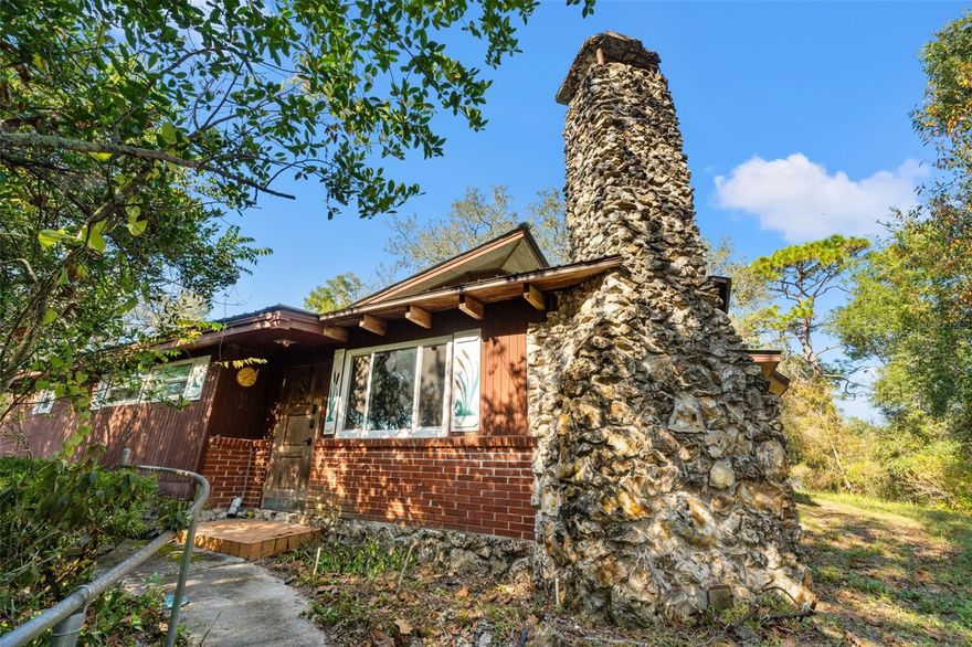 Great Mid Century Modern House with separate upstairs apartment!
NO HOA and NO CDD! Great mid-century modern house just waiting to be brought back to its
former glory. This property sits on almost an acre of private, secluded land, offering a true hidden
oasis with no restrictive community rules. River and Trail access. All appliances are included:
Dishwasher, Range, Refrigerator, Washer, and Dryer. Enjoy peace of mind with extensive updates
since 2022, including a New AC, New Water Heater, New Hurricane Windows, and newly installed
laminate and tile floors. Also a new well water pump. This home has a newer Metal roof. The
Primary Bedroom has also been beautifully updated. All of this and custom fitted remote controlled 
electric blinds. The main house features 3 bedrooms and 2 bathrooms, with both a
living room and a cozy family room featuring a fireplace. Just outside the door is a large, convenient
laundry and storage area. The possibilities are vast: The property includes a huge 3-car carport with
a separate small apartment above it, perfect for guests, income, or a home office. The well has its
own private building. Additionally, there is a massive 792 square foot workshop with electricity with endless
potential uses, and a substantial outbuilding previously used for exotic birds, which could be
repurposed for raising chickens or rabbits or storing all your vehicles and toys. This compound
offers so many possibilities and must be seen to be appreciated. Located minutes from Dade City's
historic downtown, the Giraffe Ranch, and the Pioneer Florida Museum. Hurry and schedule your
private tour today.