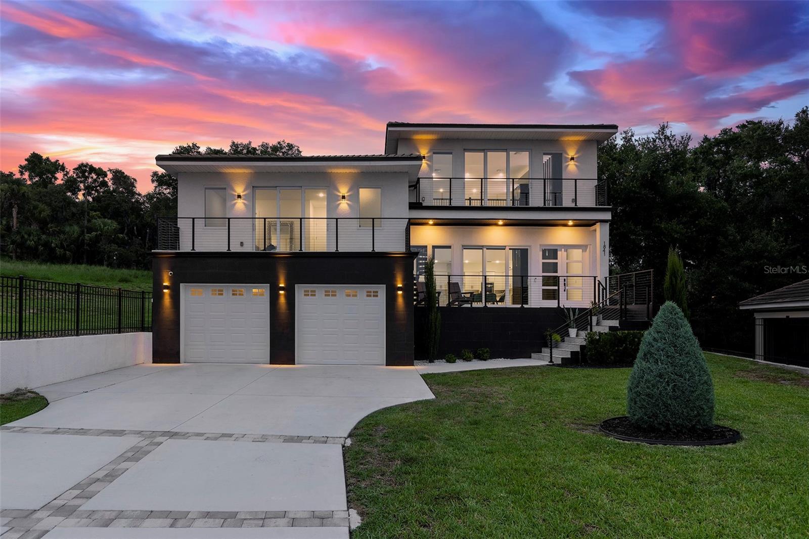 Meticulously designed contemporary residence nestled in the gated enclave of The Moorings of Clermont. Situated on a unique oversized lot on a quiet cul-de-sac boasting the most impressive lake views and sunsets. This private enclave only has 15 developable estately lots and located off South Lakeshore Drive adjacent to the impressive Lake Minnehana. This burgeoning city is located just 18 miles to Disney World or about an hour to Tampa. This home presents a rare opportunity for those interested in superior contemporary living with incredible 22-foot high ceilings, 5 ensuite bedrooms, 5.5 bathrooms, a massive 657 square feet two-car garage, 3,859 square feet of interior living space and over 6,039 square feet of total space! ADDITIONALLY, SALE INCLUDES NEW RECENTLY PURCHASED BOAT, NEW BOAT TRAILER, AND NEW BOAT LIFT!! Home features a breathtaking slice of paradise nestled among other prestigious homes full of Spanish Moss tress and walking distance to The Moorings clubhouse on the Lake. Home has plenty of room to add a pool in the backyard! Property offers its occupants seamless indoor and outdoor living spaces with breathtaking elevated views from nearly every room. This entertainer's and boater's dream home comes with a recently installed private boat lift. Detailed and thoughtfully designed home with many recent custom upgrades by the sellers! Interior features include extensive modern finishes, eat-in kitchen, and airy coastal vibes throughout. Exterior features complete PGT impact windows, impact doors including garage door, multiple balconies, spacious front porch and covered patio, elongated decorative driveway that can fit many vehicles. Interior features quartz counters, designer custom cabinetry, walk-in closets, ZLINE stainless-steel appliances and six-burner gas stovetop complete with extending pot filler, laundry room with washer and dryer. Full alarm system with six (6) cameras, Nest thermostats, custom double pantry, custom entertainment walls and accents walls throughout with incredible LED lighting, tankless hot water system, electrical power shades, Porcelain floors throughout interior and exterior living areas and bathrooms, luxury vinyl in primary master suite, and carpet in additional bedrooms. Seller recently installed a new 4,000lb boat lift. Seller is including their recently purchased new 2024 Yamaha AR195 (19.5ft) supercharged jet boat with 7k in stereo system upgrades, navigation and fish finder. Boat has less than 10 hours used on it. Minutes to downtown, entertainment, shops, restaurants and more! Sale includes a limited home warranty until 08/29/28.