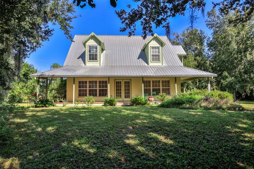 Private country retreat on over an acre - you are sure to enjoy this tropical oasis nestled among lush native vegetation. This two story, 3 bedroom, 2 bath home overflows with charm from top to bottom. From the upstairs dormers to the open loft, soaring ceilings and wrap around porches you cannot help but slow down and relax. The generous master suite fills the whole upper floor complete with several walk in closets, dormer seating area and large loft open to the spacious downstairs living area. The en suite bath has a full size tub and stand up shower, double vanity. and private water closet.  Downstairs are two additional bedrooms and a large bathroom with tub/shower combination. The sunlit living room has soaring ceilings and built-in shelves, it adjoins the open dining area and large kitchen with center island. There is also an indoor utility room off the kitchen complete with washer, dryer and laundry sink. The back porch is screened to enjoy the river breezes and overlooks the fenced and gated yard. There is a double carport, detached garage/workshop with additional covered area and plenty of room to park your RV or boat. Tropical plants, lush lawn and majestic oaks grace the property - all this just steps from the Intracoastal Waterway, great redfishing & shrimping in Mosquito Lagoon. Oak Hill is home to the A Rated Burns Sci Tech Charter School and Seminole Rest Historical Site, part of the Canaveral National Seashore. Easy commute to Orlando, Cape Canaveral or Daytona. USDA eligible area, possible 100% financing for qualified buyers.