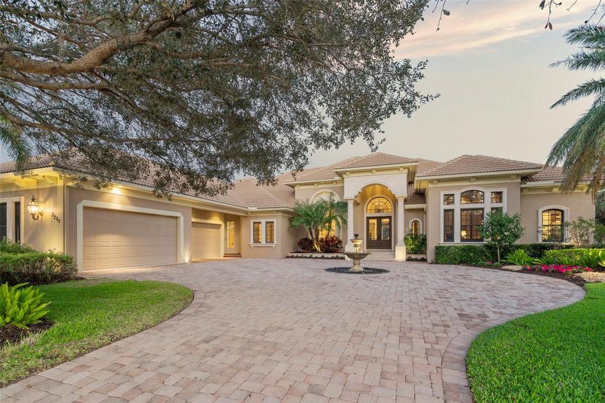 Showcasing a picturesque panorama of golf course, lake and nature views, this John Cannon Homes Elanora custom home in The Founders Club offers a dramatic, classic design with generous indoor-outdoor entertaining spaces, soaring ceilings and luxurious appointments and finishes throughout. Beautifully manicured landscaping and a circular paver drive with a lovely fountain welcome visitors to the nearly 6,000-square-foot single-level home, situated on a private .71 acres on a cul-de-sac in the community’s estate section. Captivating outdoor views and impeccable attention to detail are evident from the moment you enter the grand foyer, which has a nearly 20-foot-high ceiling, striking chandelier and marble floors that flow into the elegant living room and dining room, which also boast impressively high ceilings with craftsman details. The beautifully appointed living room features a coral stone fireplace, built-in custom cabinetry and 10-foot French doors that open to a voluminous screened lanai with a large, heated pool and spa, open areas and a covered patio with an outdoor kitchen, stone fireplace and abundant space for dining and entertaining amid the serene surroundings. Three pairs of tall French doors transition to the spacious family room and well-appointed gourmet kitchen with high-end, wood paneled appliances, oversized island, walk-in pantry, butler’s pantry, wet bar and a breakfast area with an aquarium window overlooking the lanai. Guests will be enthralled with the home’s additional entertainment spaces, including a gorgeous 26’x-26’ sunken octagonal bonus room off the family room and a 24’x16’ media room. On the opposite end of the home, a charming hall off the living room leads to the handsome library and expansive owner’s suite with an elegant sitting room overlooking the lanai, two sizable closets with built-ins, and a sumptuous bathroom with a large tub, oversized walk-in shower, two vanities, separate makeup area and linen towers. Three additional bedrooms and full bathrooms are located in two separate wings, providing comfortable, private accommodation for overnight guests. Other notable highlights of this fabulous home include a 4-car garage and a Crestron home-automation system. The guard-gated Founders Club is located on 700 acres of breathtaking lakes, mature oaks, nature preserves, and a recreation center complete with tennis / pickle ball and basketball courts. In addition, the community offers membership to the Robert Trent Jones Jr.-designed 18-hole championship golf course and the 24,000-square-foot clubhouse with a restaurant and bar and fitness center. Close to shopping, downtown and the world’s most coveted beaches, The Founders Club, is a private community for only a select few.