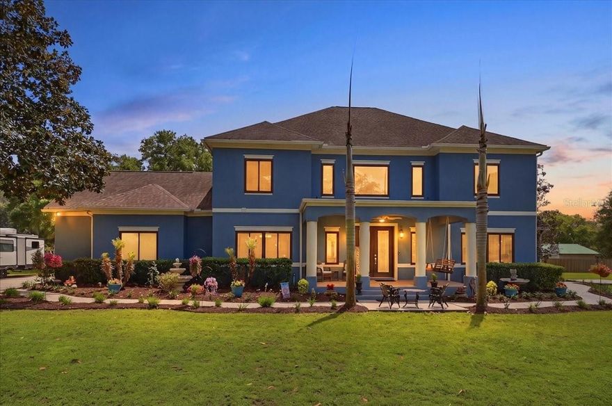 This luxury estate in North Lakeland, Central Florida sits on 1.95 acres on a quiet, private drive with only seven homes. The property is zoned for horses and approved for a home-based business. The home welcomes you with 8-foot French doors opening to a grand foyer and soaring 25-foot ceilings in the main living area. Enormous windows flood the open floor plan with natural light. Architectural details include arches, columns, and a stone half wall separating the foyer from the living area. The living room features vaulted and cathedral ceilings, double doors to the backyard, and a gas fireplace with a stylish two-tone gray brick/tile surround that perfectly complements the gray tile floors. The remodeled kitchen features quartz countertops, solid wood cabinetry including glass-front cabinets, and a tiled backsplash that matches the fireplace, creating a cohesive design. Additional highlights include a dry bar with built-ins and microwave, and a kitchen island with a sink and extra cabinetry. The stainless steel appliances include a double oven, dishwasher, and large refrigerator. An attached eating area with a chandelier, large windows, and sliding doors to the backyard creates a bright, airy space. The first floor also offers a formal dining room, a convenient half bath, and an office/den with abundant windows and a closet that could also serve as an extra bedroom. In addition, there is a separate laundry room with ample cabinetry, countertops, and a utility sink, with a door leading to the garage, and a dual laundry chute connecting the upstairs bedrooms directly to the laundry room. The primary suite on the first floor boasts a walk-in closet and an ensuite bathroom with dual sinks, garden tub, separate walk-in shower, and built-in shelving. Upstairs, a spiral staircase leads to a balcony overlooking the main living space. Additional bedrooms are connected by a Jack and Jill bathroom with enormous walk-in closet, and there is a huge bonus room. Ceiling fans are installed throughout the home, and window treatments along with hurricane/impact-resistant Andersen windows provide both elegance and protection. Outdoor living is enhanced by two covered porches, a side patio, a partially fenced backyard, a 50-amp RV hook-up, a utility shed with electricity, an oversized garage, an irrigation system, professionally landscaped grounds, and a new well installed in 2025. Additional features include electronic blinds, Ring security cameras, a newer roof (2021), three A/C units (2022), upgraded attic insulation (2023), and a 74-gallon propane water heater. Ideally located minutes from Publix, shopping, and dining, and right off Kathleen Rd with easy access to I-4, Tampa, Orlando, and 570, this property offers the perfect blend of rural tranquility and city convenience. Please note the following items will not convey with the sale: fountains, garage rack system, mounted TVs, gray shed in the backyard (not attached), countertop microwave, front porch swing, and hanging plant baskets and staghorns. Additional note: Seller is willing to remove the dog pen in the front yard prior to closing if the buyer does not want it.