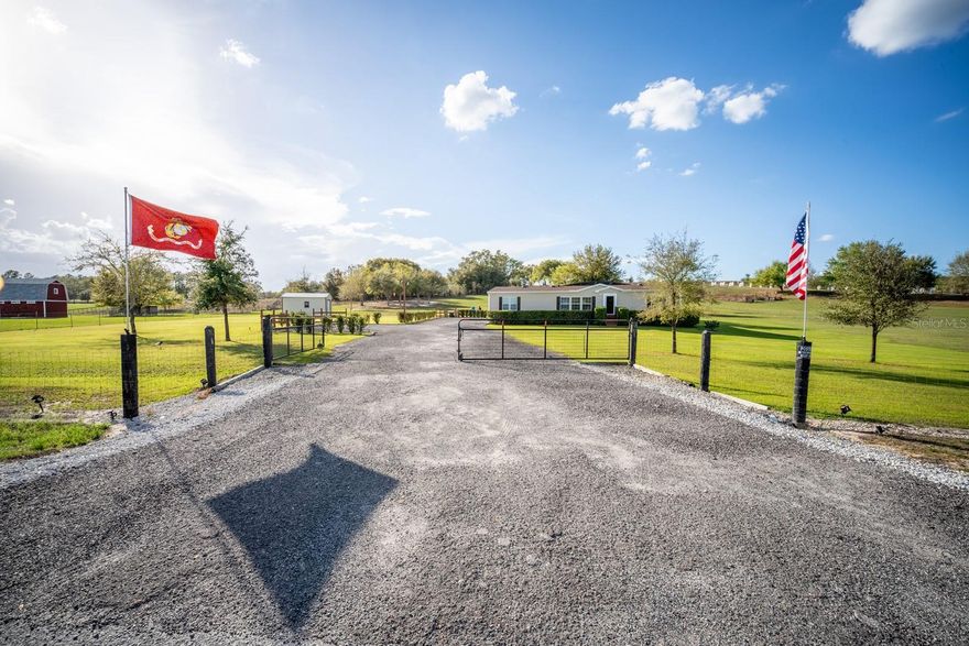 Discover peaceful country living with modern convenience on 3.05 acres of tranquility! Built in 2020, this 1,980 sq ft double-wide manufactured home offers 3 bedrooms and 2 bathrooms with thoughtful upgrades throughout. A brand-new roof (2025) adds peace of mind, while a Bluetooth digital thermostat enhances comfort and efficiency. When you enter the home, you’ll be impressed by the attention to detail and spacious open layout. The large kitchen features a generous island with sitting area for 6 people, abundant cabinetry, and plenty of space for cooking and gathering. Elegant vinyl plank flooring flows throughout the home with no carpet, creating a modern and low-maintenance living space. The primary suite offers a spacious bedroom and a beautiful bath with dual vanities, a relaxing garden tub, and a walk-in shower. The home also features two additional large bedrooms and a second full bathroom, providing plenty of space for family, guests, or a home office. Outdoor living truly shines with a 50x20 screened deck—perfect for relaxing while enjoying wildlife, sunsets, and peaceful lake views with lake access. Cool off in the above-ground pool and enjoy the recently installed winter rye grass, the envy of the community. This is one of only two homes in the neighborhood with a full irrigation system. Designed for versatility, the property includes an electric car charger and RV hookups with 30- and 50-amp service. An additional RV setup with power, water, and a waste dump station offers excellent potential for guest quarters or income opportunities. The 18x20 powered workshop with a concrete floor can also be used as a garage. The property is fully fenced and features a long driveway with offset parking for added convenience. Ideally located just minutes from Lake Harris, Downtown Clermont, Downtown Tavares, Mission Inn Resort with championship golf courses and restaurants, and JB Boondock’s Bar & Grill. This unique property offers space, flexibility, and an unbeatable lifestyle opportunity. Schedule your private showing today!