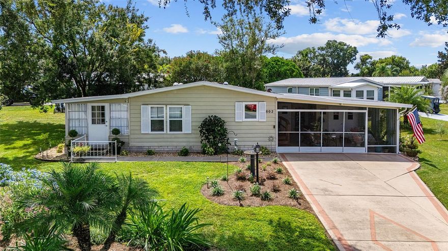 Beautifully updated 2 bedroom, 2 bath corner lot home with 1,196 sq ft of living space, featuring luxury vinyl floors, new windows (2025), roof (2024), HVAC (2025), water heater (2024), and granite countertops in the kitchen (2024); the kitchen also includes a farmhouse sink, pantry, breakfast bar, and all newer GE appliances, while the spacious living room offers solar tubes, a ceiling fan, and sliding doors leading to the enclosed lanai; the inviting primary suite features two walk-in closets and an en suite bath with a large tiled step-in shower, grab bars, seat, and built-in cabinetry; additional highlights include a cozy guest wing with walk-in closet, dining room with built-in hutch, outdoor laundry room with sink, expansive 20x21 Florida room with painted concrete floor and golf cart storage, covered lanai with cottage door and windows all around, plus a beautifully landscaped yard with flower beds, gutters, and downspouts – a warm and welcoming home with thoughtful modern updates throughout.