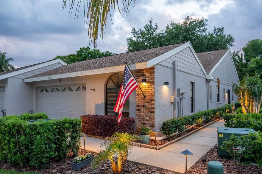 Proudly owned by only its second owner since built in 1990, this home has been cared for and transformed with extraordinary pride of ownership. Where every room, every system, and every detail has been replaced and elevated with premium materials and true craftsmanship. Located in the gated community of Salem Village at Ridgemoor, this stunning 3-bed, 2-bath home with a 2-car garage overlooks a serene pond and offers a level of finish rarely seen at any price point.
Volt landscape lighting on a timer illuminates mature palms, fresh tropical plantings, and meticulously clean landscaping the moment you arrive. Newly painted exterior window trim and updated wall-mounted exterior light fixtures create a polished, welcoming first impression.
From the moment you enter, soaring vaulted ceilings — with all popcorn ceilings removed and replaced with smooth, flat, clean finishes throughout — and dramatic custom white wood beams command attention. The open-concept layout between the kitchen and living areas, features bamboo hardwood floors throughout, abundant recessed lighting, wall sconces, custom base moldings, wood window sills, and beautiful stained knotty pine interior doors — all replaced. The wood-burning fireplace has a clean modern surround and warm wood mantel. Sliding glass doors open to a freshly re-screened and repainted lanai with peaceful pond views. The dining room impresses with a vaulted ceiling, arched window,  woven chandelier, and elegant wainscoting panels.
The kitchen is fully custom — white shaker cabinetry, granite countertops, arabesque mosaic backsplash, and a complete KitchenAid suite: French door refrigerator, dishwasher, electric cooktop, double wall oven, microwave, warming drawer, and stainless range hood. Under-cabinet LED lighting, island pendant lights, and a built-in reverse osmosis drinking water system complete the space. The home also features a private interior atrium — a charming courtyard accessible via sliding glass doors that floods the home with natural light.
The master bathroom is a showstopper: floor-to-ceiling dramatic blue and gold large-format tile, frameless glass shower with ceiling-mount rain head and Grohe thermostatic controls, illuminated shower niche, double quartz sinks with layered lighting including toe-kick glow, Grohe heated towel warmer, and a Toto toilet. The guest bath is equally refined with custom artistic tile, Grohe fixtures, quartz vanity, warm LED crown cove lighting, and a Toto toilet.
Every bedroom features recessed lighting, custom closet shelving, updated ceiling fans, and new window shades. All bathrooms have dedicated exhaust fans for moisture control. Cat-5 low voltage wiring installed throughout for modern connectivity. Entire attic insulation blown in for year-round energy efficiency and savings.
All systems are brand new: HVAC and air handler, tankless hot water heater, complete attic plumbing replacement, whole-home water softener with carbon filtration, and a dedicated drinking water filter. The garage features an epoxy flake floor with recessed lighting. All outlets and switches replaced throughout — many with built-in USB charging ports.
Salem Village at Ridgemoor is a gated, tile-roof villa community offering a heated pool, tennis and basketball courts, walking trails, and a park. Minutes from top-rated schools, Gulf beaches, Lake Tarpon, the Pinellas Trail, and Tampa International Airport.
HOA: $540/month — includes lawn care, landscaping, trash, cable