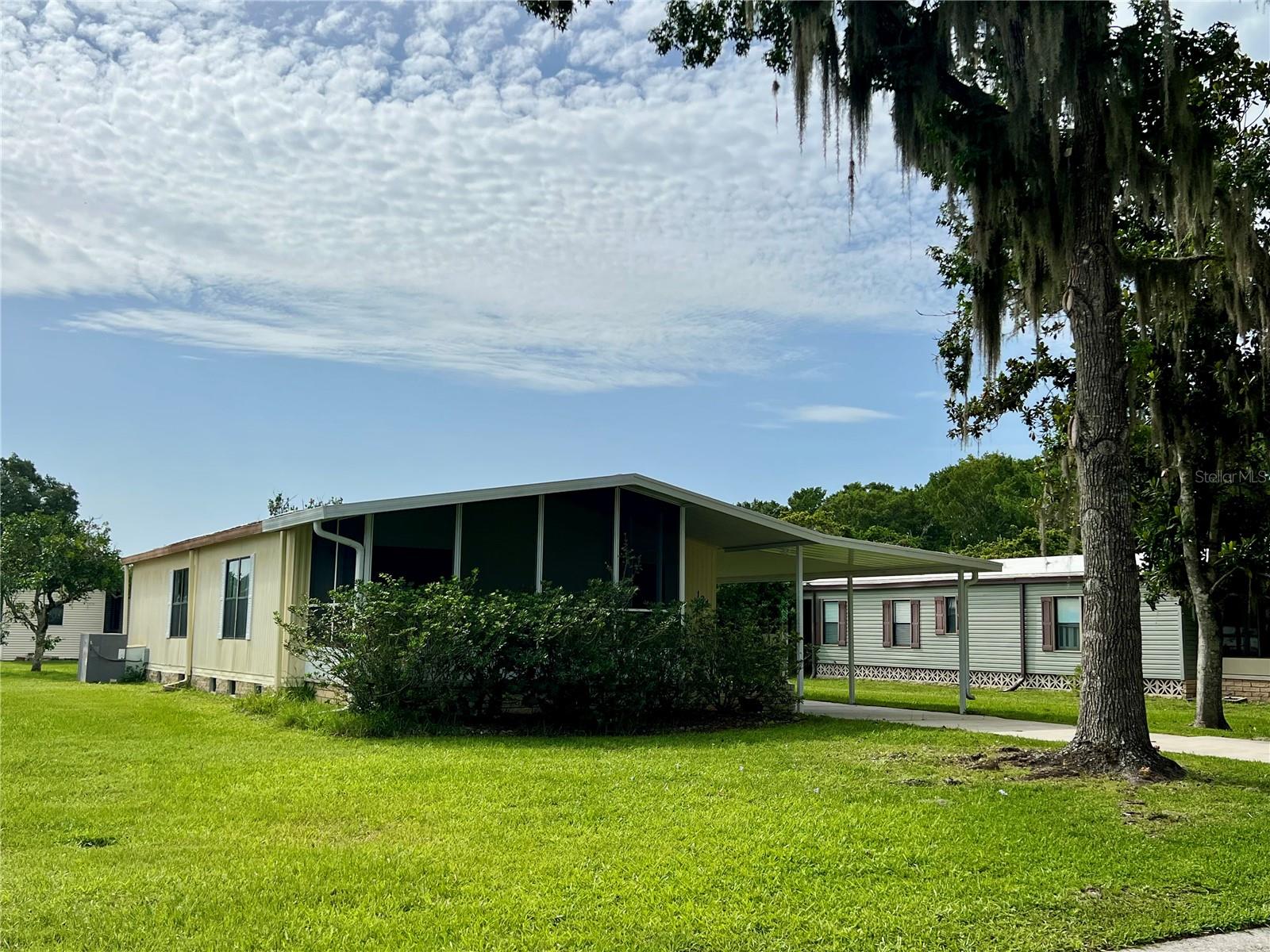 Welcome to your Florida retreat! This beautifully enhanced 2 bedroom, 2 bathroom home is move-in ready and thoughtfully designed for comfort and easy living. Situated on a spacious and open lot, the home features a deep carport, newer appliances, and comes furnished, offering a wonderful opportunity for a seamless transition to your new lifestyle. Enjoy peaceful mornings or relaxing evenings in the updated screened-in room, a perfect spot to unwind and take in the tranquil surroundings. The light and bright kitchen creates an inviting space for cooking and gathering, while the open layout throughout the home provides a welcoming atmosphere filled with natural light. Located within a vibrant, 24-hour guard-gated golf community, this property offers access to a wide range of amenities including a championship golf course, on-site restaurant with dancing and live entertainment, a fitness center, gym, exercise classes, pickleball and tennis courts, billiards, a dog park, woodworking shop, craft room, and so much more. Outdoor enthusiasts will love the easy access to Lake Okahumpka, ideal for kayaking, fishing, and enjoying the natural beauty of the area. With a variety of clubs, social events, and activities available, there's always something to do and new friends to meet. Whether you're looking for an active lifestyle or a peaceful place to relax, this community and home provide the best of both worlds. Don’t miss your chance to own a slice of Florida paradise—schedule your private showing today!
