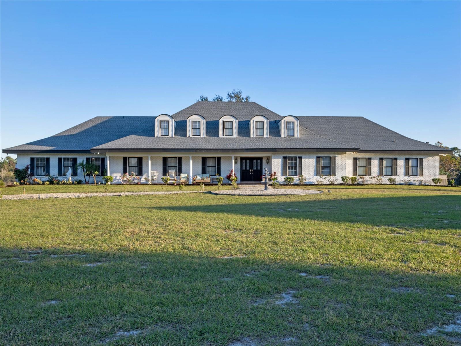 Discover a rare opportunity to own this stunning almost 20-acre estate in the heart of Oviedo, FL—fully turnkey, income-producing, gem nestled in peaceful Oviedo, just minutes from Winter Park, UCF, and major highways and airports, while still offering convenient access to Central Florida’s world-renowned theme parks like Disney World and Universal Studios—just a reasonable drive away for day trips or visiting guests.. Zoned agricultural with FLU designation for future residential development, this property offers unmatched flexibility with NO HOA or deed restrictions. The spacious 5-bedroom, 4.5-bath Farmhouse-style main home spans 5,737 sqft and features grand living spaces, two Florida rooms, game rooms, a spa room, and a brand-new saltwater pool, perfect for relaxation or guest enjoyment. It is currently a fully operational and turnkey business that includes a lodging and event venue establishment, and is already licensed on Airbnb with a Superhost status, but can be used as a private estate, agritourism business or convert to an assisted living facility, rehab center etc (buyers to verify with county). This operational farm stay includes over 4000 mature blueberry bushes, cattle, farm equipment and more. The property also includes a generous three-car garage, a versatile red room that is perfect for a wine room or storage. Let's not forget the newly constructed 2,400 sq ft event barn that is ideal for weddings, retreats, or future expansion. Whether you're seeking a private retreat, event venue, or long-term investment, this one-of-a-kind property offers beauty, tranquility, and strong income potential—fully furnished and ready to go. Whether you aspire to expand the existing agritourism business or explore new ventures in the vibrant agricultural industry, this property is an unparalleled opportunity to turn your dreams into reality. Unleash your vision, creativity, and entrepreneurial spirit to transform it into a haven of happiness and lucrative income-generating ventures. Seller financing available with no payments due the first two years. Business plan available for serious buyers.