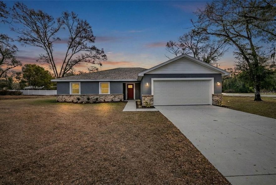 Why wait on new construction when you can move right into a nearly brand new home set on
almost half an acre with no HOA? Built in 2024 and beautifully finished, this 4 bedroom, 2 bath,
2 car garage home offers the space, style, and freedom today’s buyers are looking for, all
perfectly positioned on a generous corner lot in an easily commutable Dade City location. Arrive
to a charming exterior highlighted by stone accents, thoughtful landscaping, exterior lighting,
and a welcoming covered entryway. Inside, a sweeping open concept design unfolds, anchored
by a spacious 16 x 22 living and dining area with luxury vinyl plank flooring, soaring ceilings,
and French doors that open to the expansive covered back porch, creating an effortless
connection between indoor and outdoor living. At the heart of the home, the eat-in chef’s kitchen
shines as the true centerpiece of the space. Designed with functionality and style in mind, it
offers sleek stainless steel appliances, granite countertops, a matching granite backsplash, elegant
pendant lighting, and a large island with breakfast bar seating that invites conversation, casual
dining, and easy entertaining. Privately tucked away from the secondary bedrooms, the primary

suite provides a comfortable retreat with plush carpet flooring, dual walk-in closets, and a well-
appointed ensuite bathroom. Here you will find a custom walk-in shower with decorative tile

work and glass enclosure, dual sinks, a separate vanity counter with an LED-lit mirror, and a
private water closet. On the opposite side of the home, three generously sized guest bedrooms
feature carpeted floors, ceiling fans, built-in closets, and convenient access to the home’s second
full bathroom, complete with a granite-topped sink and a striking tub and shower combination
finished with shiny porcelain tile. A dedicated laundry room, the attached two-car garage, and a
massive 27 x 11 covered back porch overlooking the expansive backyard add even more value to
this thoughtfully designed home. The nearly half-acre corner lot provides ample space to relax,
play, garden, or create the outdoor setup you’ve always wanted. Conveniently located just
minutes from charming downtown Dade City, this home is close to local schools, restaurants,
shopping, and medical facilities, while also offering quick access to major roadways for an easy
commute to Zephyrhills, San Antonio, and I-75. If you’ve been searching for space, style, and a
like-new home without the wait, this one checks all the boxes. Give us a call today to see if this
beautiful home is the one for you!